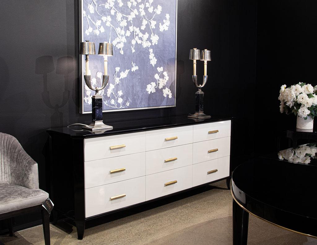 Polished Black Lacquered Sideboard by Baker Furniture Facet Cabinet. Featuring beautiful 2 tone black and white high gloss hand polished finish. Completed with sleek brass hardware. Cabinet has incredible storage with 8 large drawers. American,
