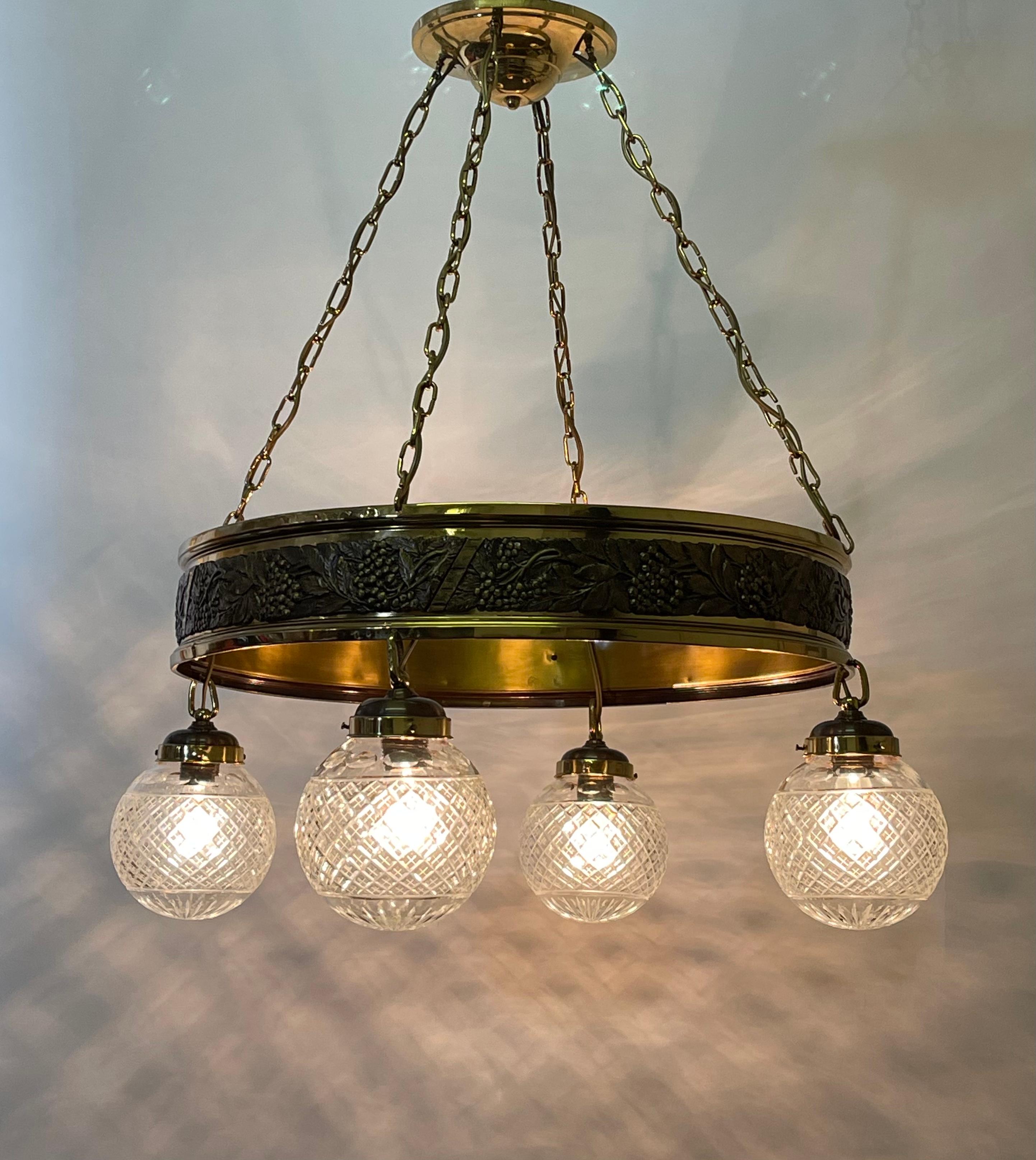 A wonderful early Art Deco chandelier, Germany, circa 1920s.
This beautiful chandelier is made of polished brass with grape motif and four cut-crystal globes.
Socket: 4 x e27 or e26 (US) for standard screw bulbs.

