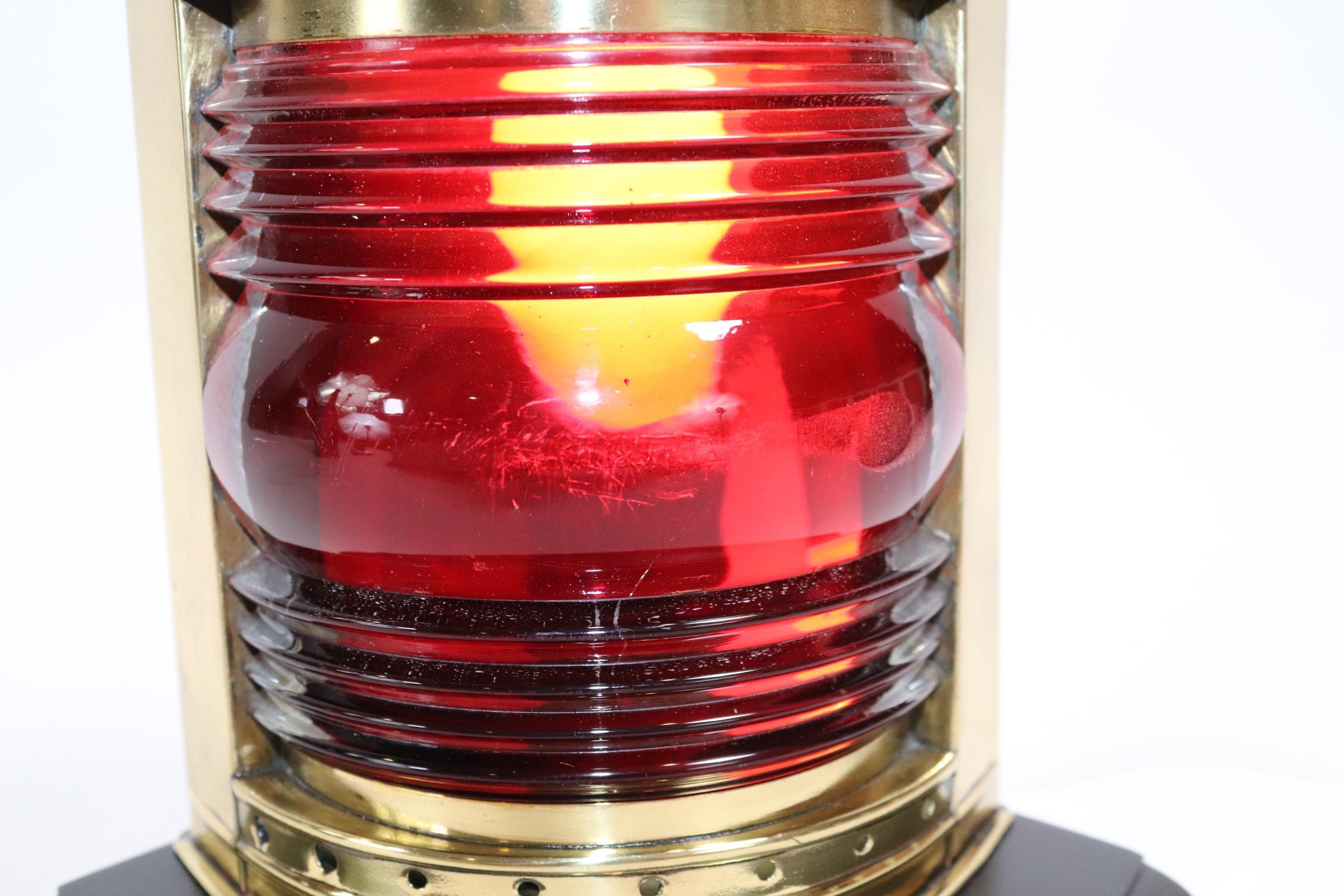 Polished and lacquered ships port lantern with rich red lens mounted to a custom wood base with rich dark finish. Weight is 3 pounds.
