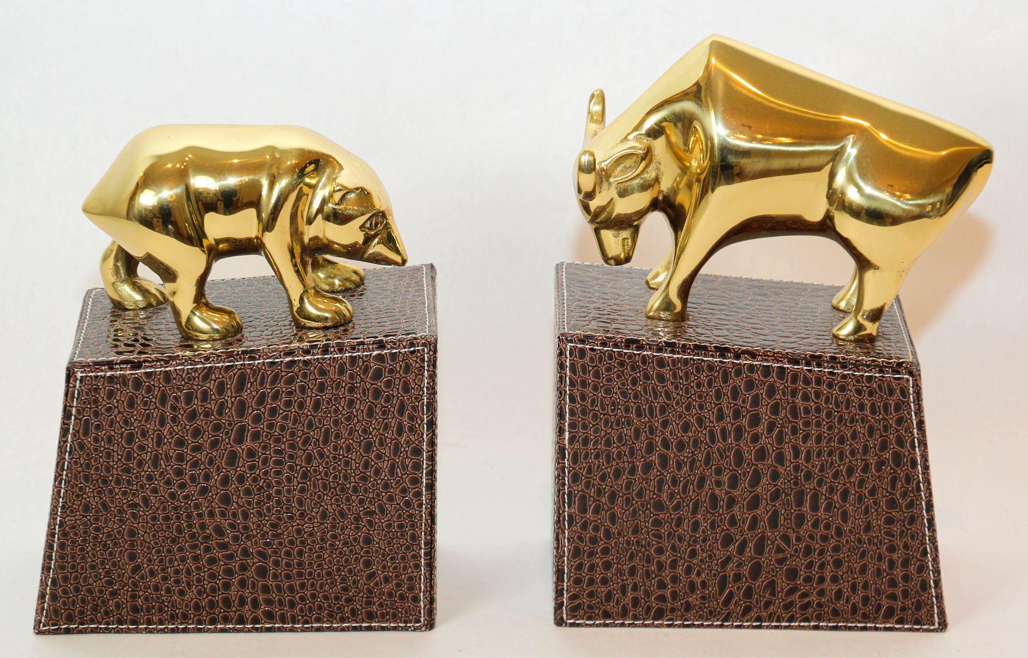 Vintage polished brass bull and bear bookends paperweights Wall Street cedor.
Great on any desk the polished brass bull and bear on stitched faux embossed leather stands bookends or paperweights.
Great decorative brass book ends. Wall Street bull