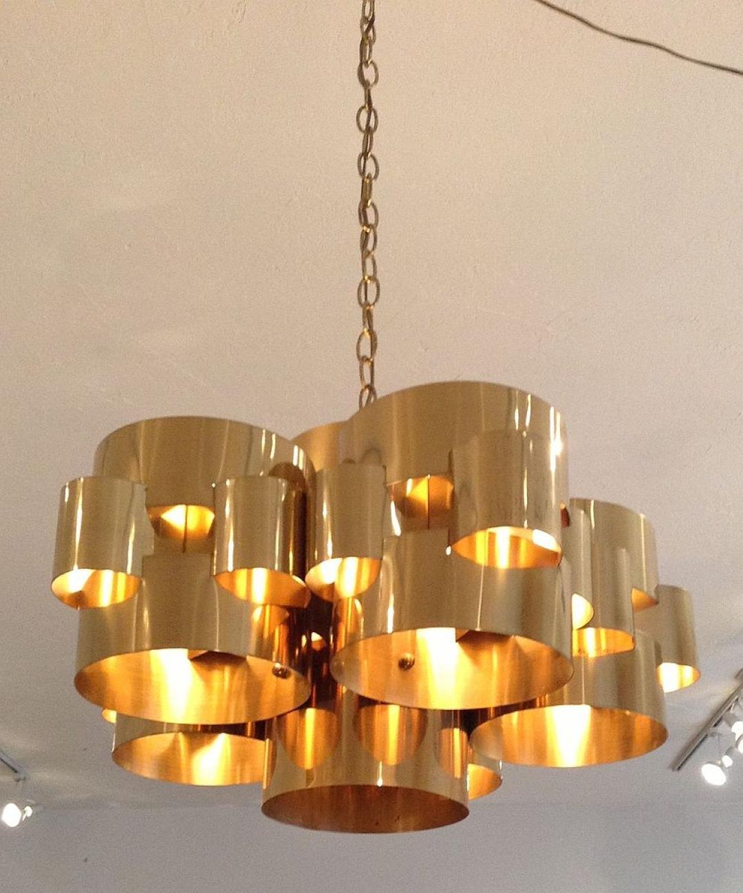 Polished brass chandelier composed of one central long cylinder flanked by five interlocking cylinders. Designed and signed by the great American mid-century designer Curtis Jere, circa 1975. 24