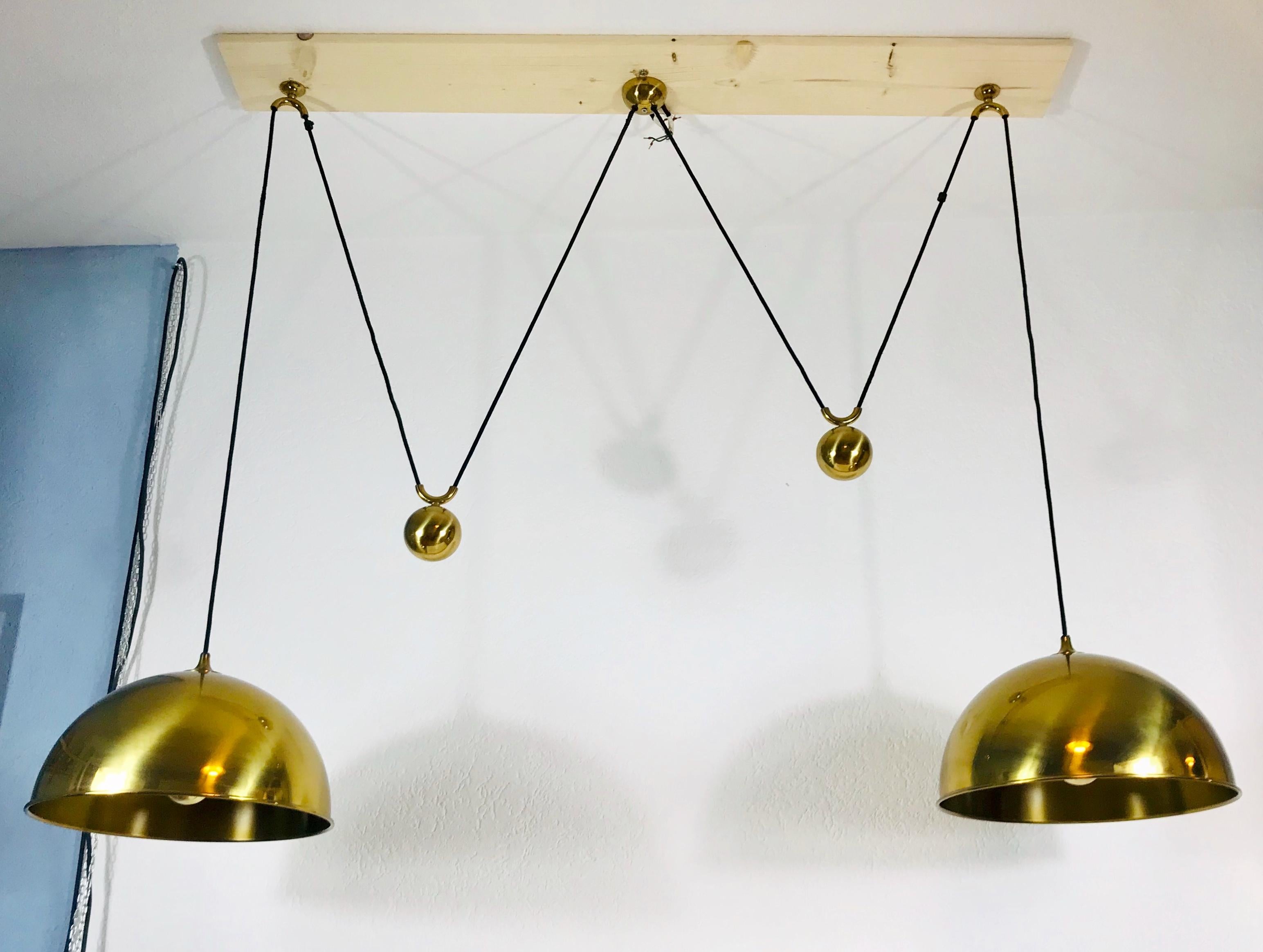 Counter balance pendants designed by Florian Schulz and made in Germany in the 1960s. It is fascinating with its exclusive design and two polished brass pendants. The height of the lighting is adjustable.

Measurements of one shade:
Height 25
