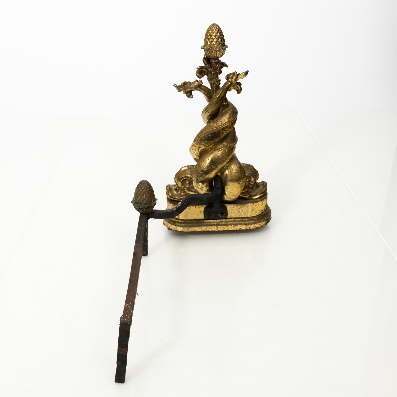 Pair of Baroque style polished brass andirons with dolphins and acorn finials, circa early 20th century.
   