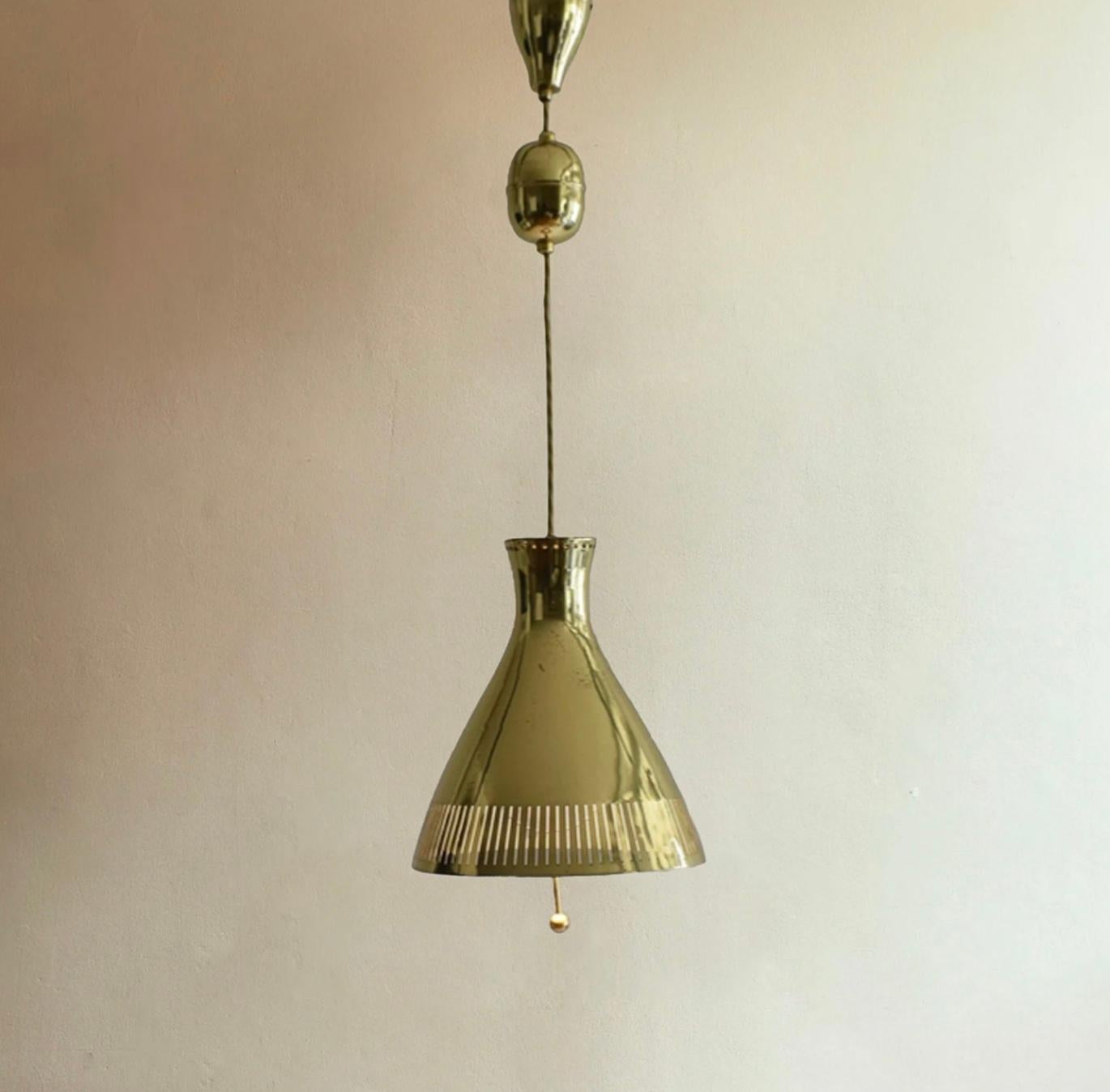 Excellent quality hanging light with a rise and fall mechanism in polished brass. 

Style of Paavo Tynell c1950s.