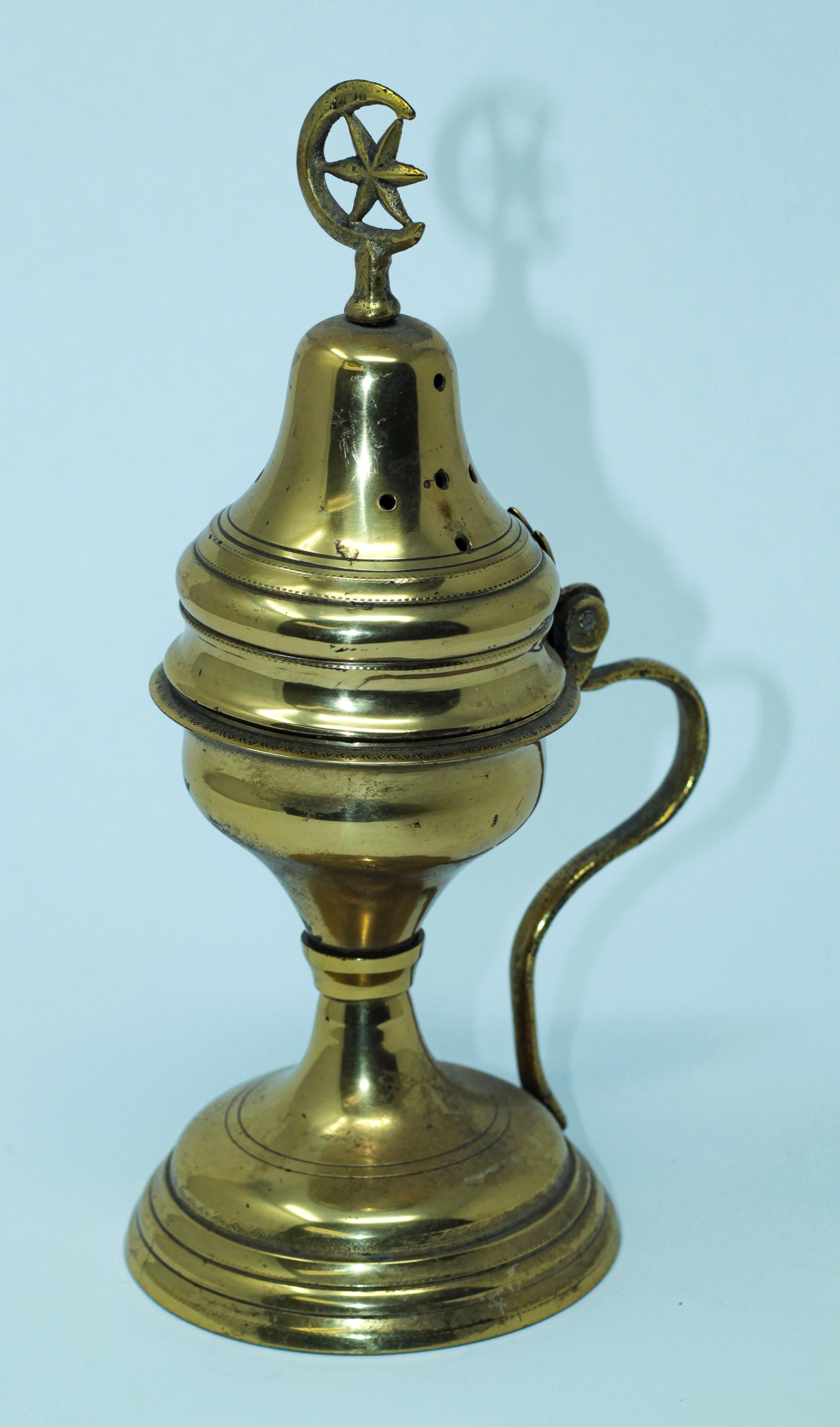 Footed antique Middle Eastern incense burner with pierced brass and solid brass ornamentation.
Decorated with a Crescent moon and star brass final.
Functional and beautifully adorned, complete with lid.
The copper bottom bowl was made to hold the