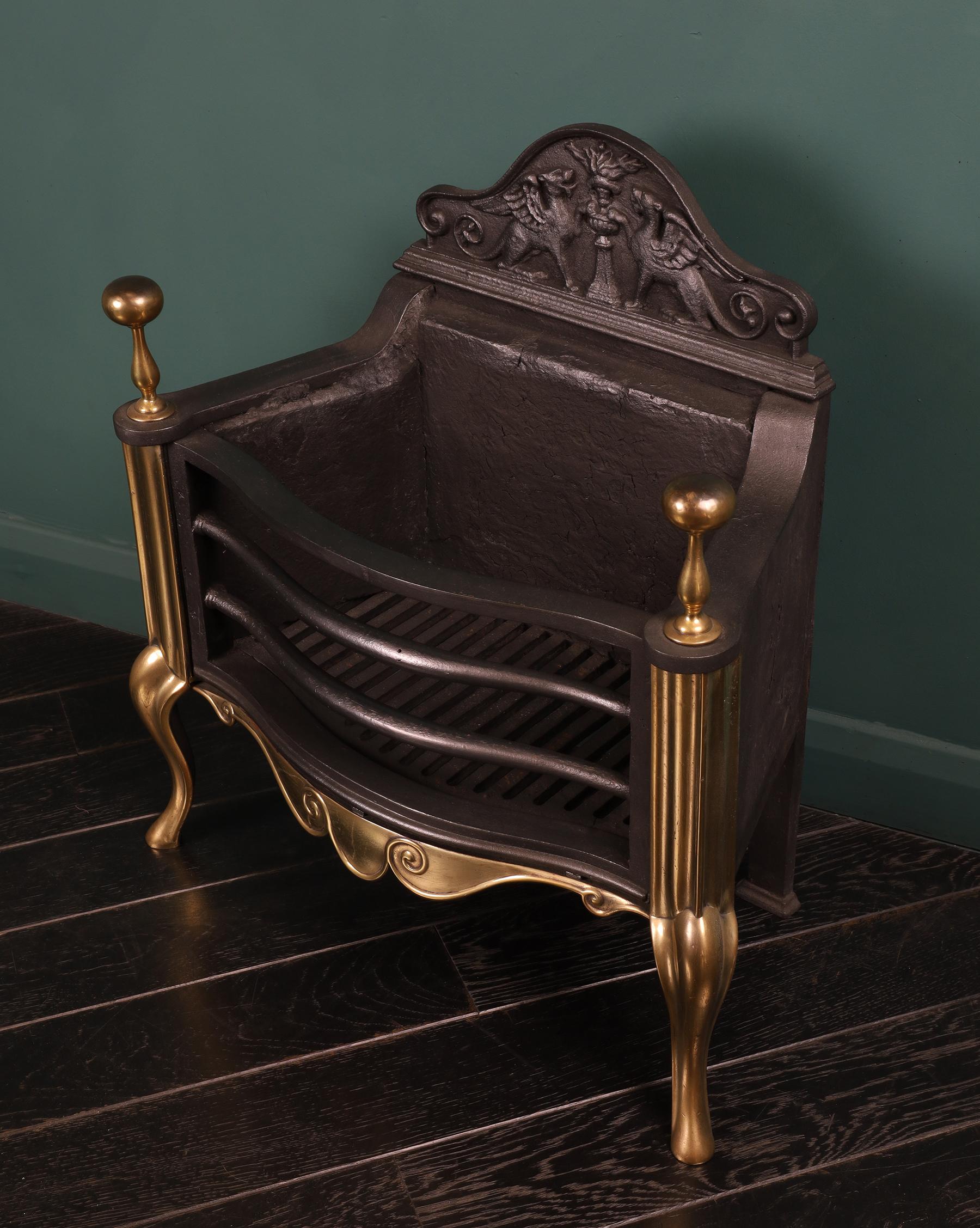 A polished brass and iron fire basket (by Thomas Elsley of London), with scrolled fret between shaped cabriole legs in the Queen Anne manner. Cast-iron shaped front bars with elegant ball finials uppermost and an ornate back plate. Height of burning