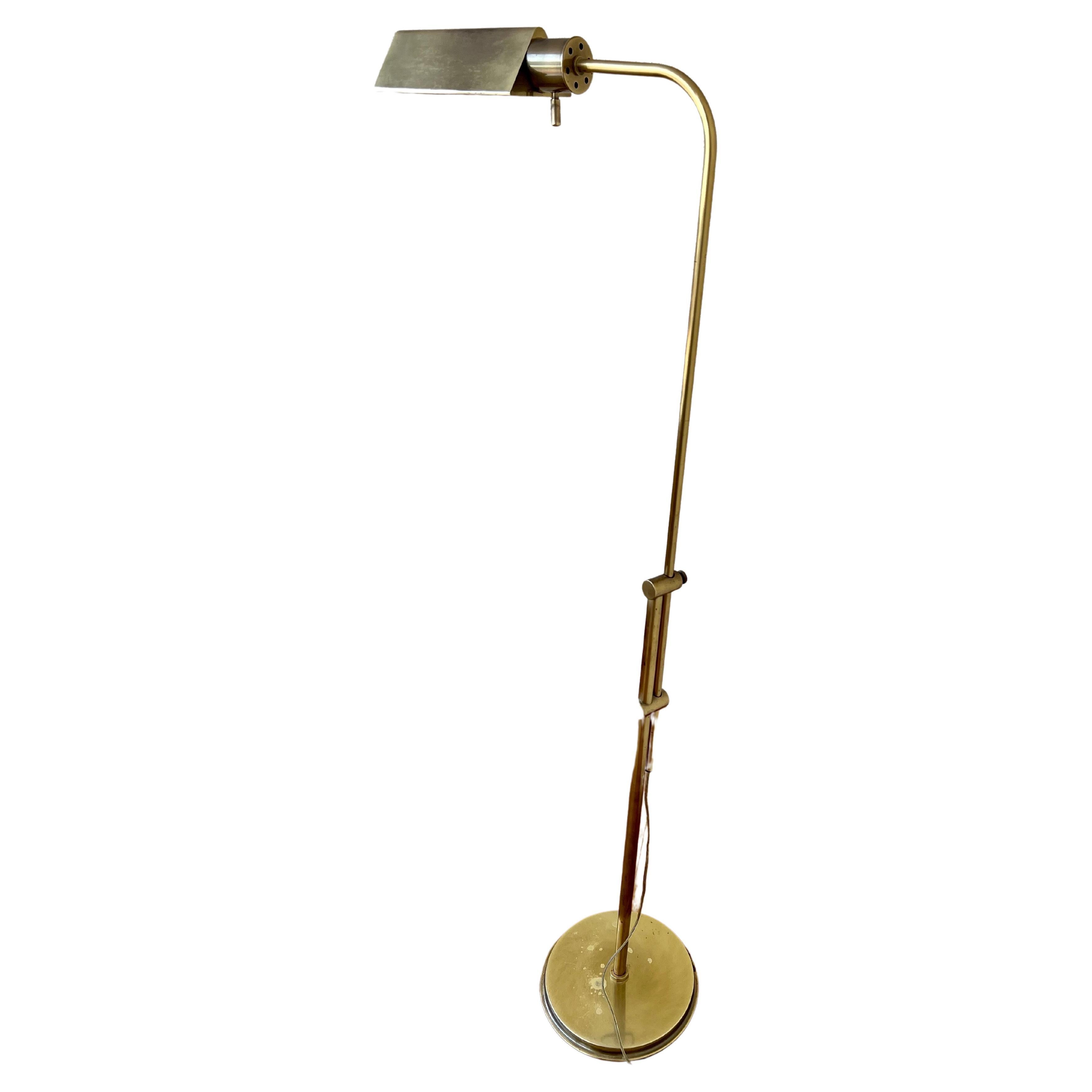 A very nice polished brass multi-directional pharmacy floor lamp by Frederick Cooper, circa 1970s. The lamp is multi-directional it goes up and down and rotates to a 360 degree and is in good working condition. with a dimmer switch The lamp can