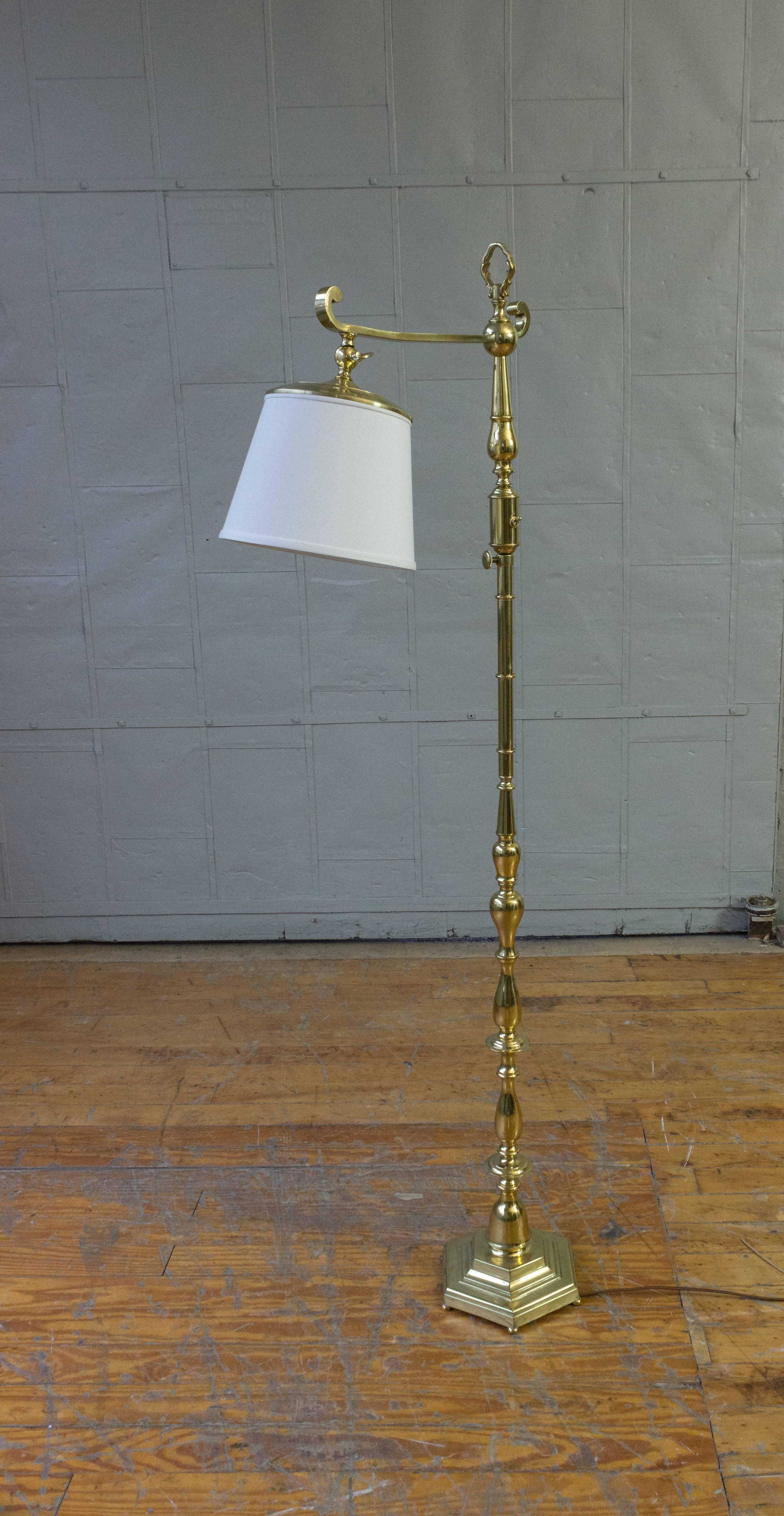 Reading lamp composed of turned and cast polished brass pieces, French, circa 1940s. The lamp has recently be rewired and is sold with a custom white linen-over paper shade. LED bulb or less than 40 watt incandescent bulbs are recommended to prevent