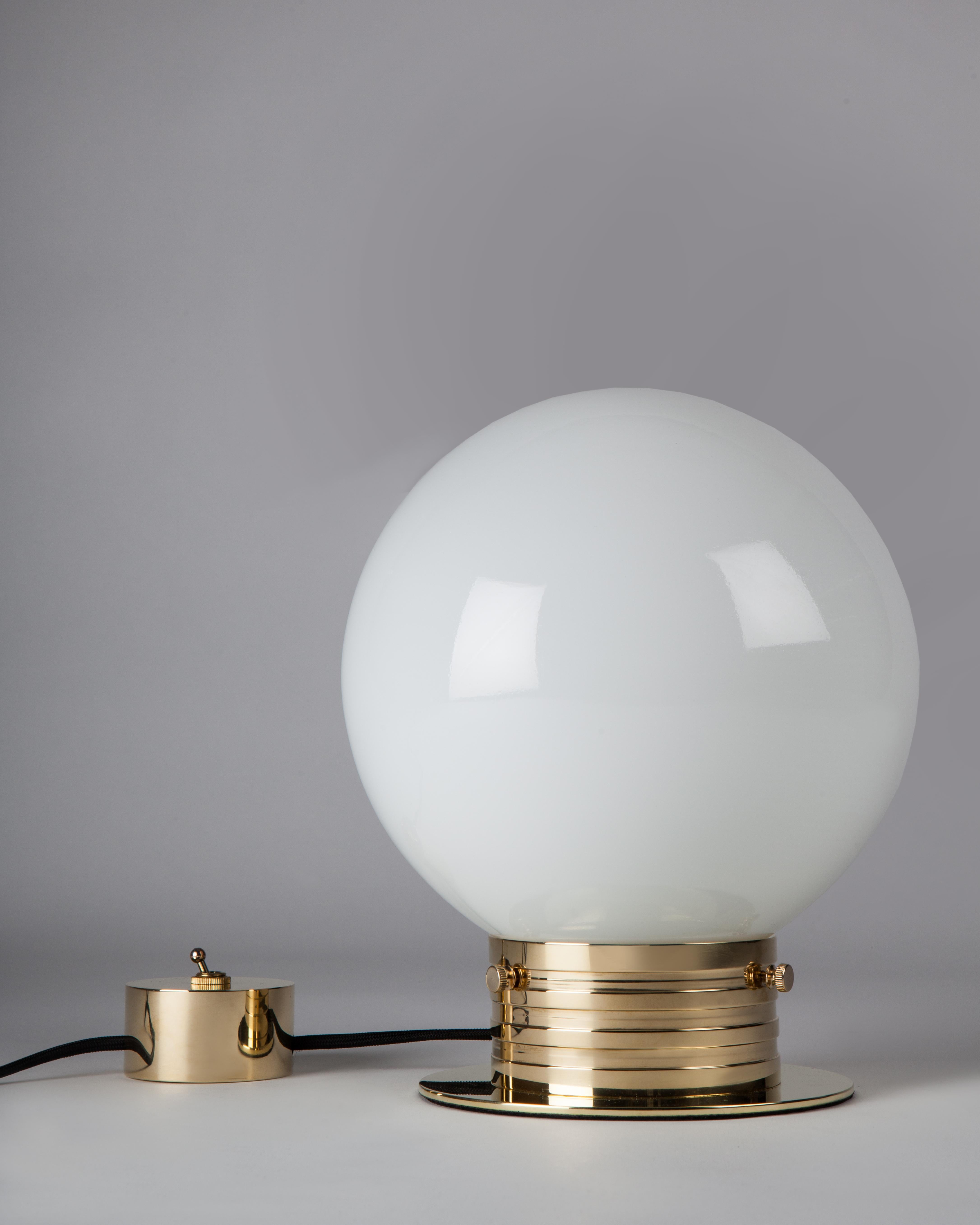 CTL3310
A utilitarian design with luxurious materials: the turned solid brass ribbed neck base of the Commune Globe Table Lamp holds a hand-blown white milk glass globe shade. A decorative cylinder form toggle switch mirrors the other round