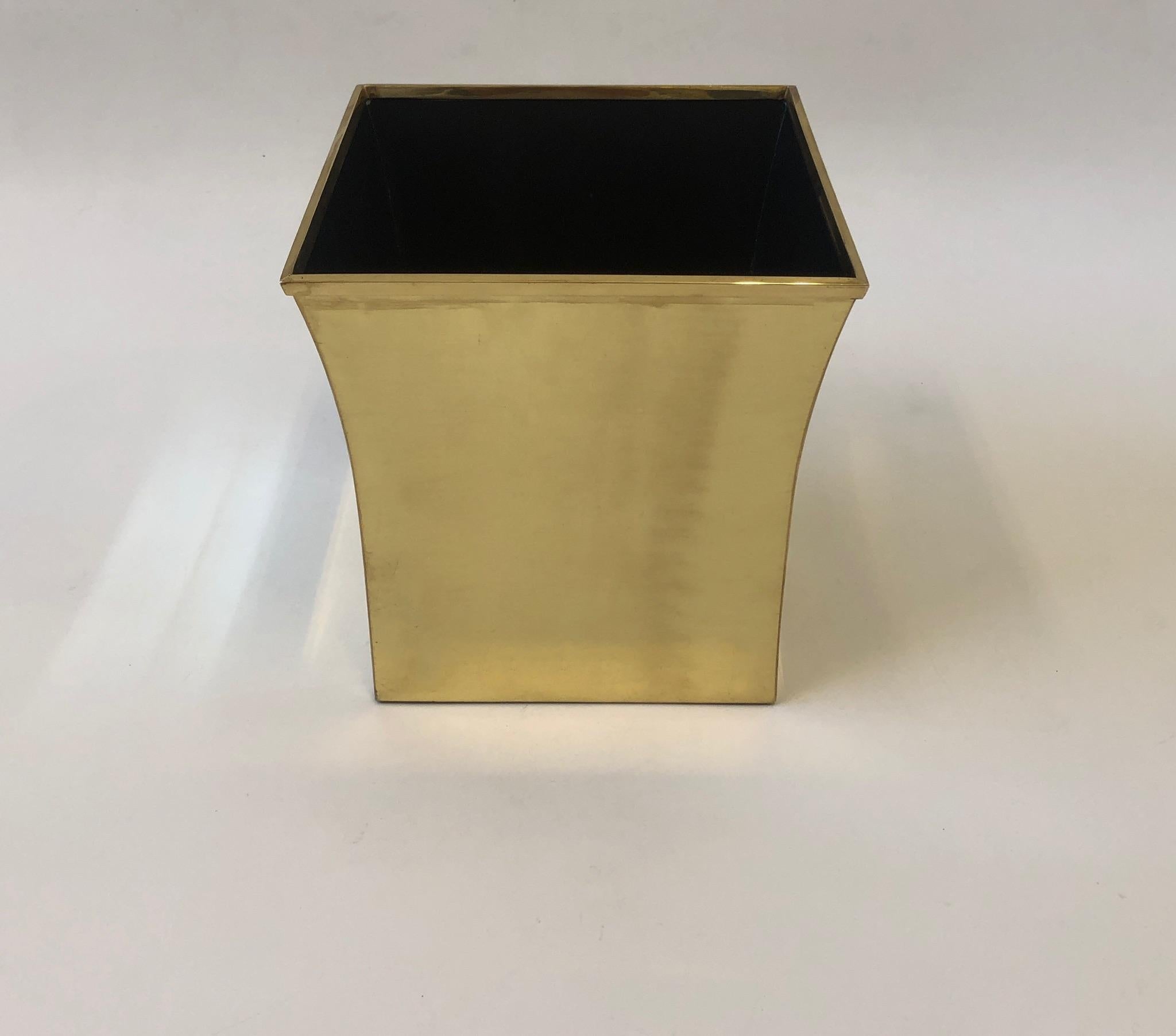 A glamorous 1980s polish brass and black lacquered wastebasket by Karl Springer. Constructed of solid brass with the inside black lacquered. Newly professionally polished and lacquered. Shows minor wear.
Measurements: 11.25” wide, 11.25” deep,