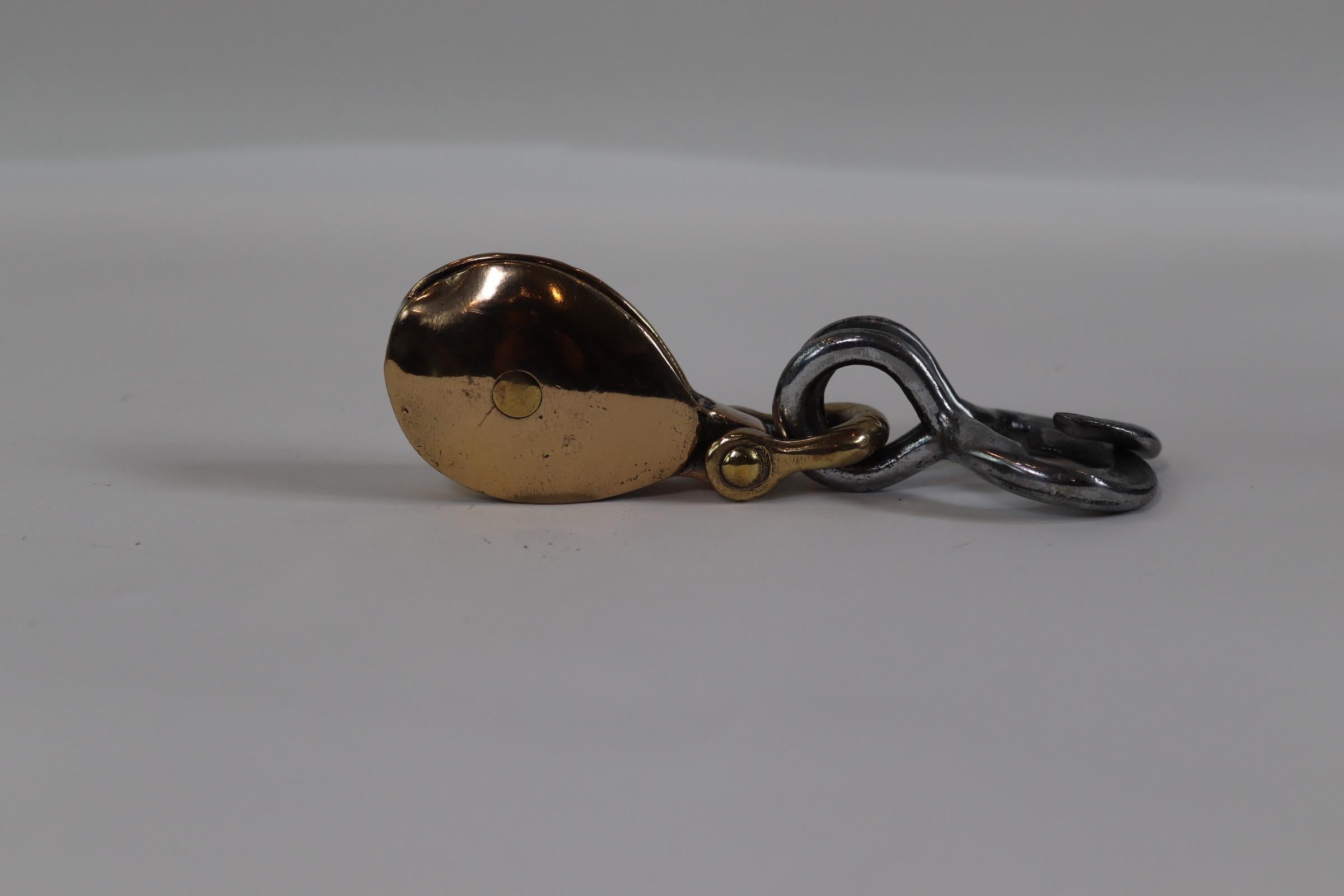 Polished and lacquered yacht pulley with two attached steel hooks. Weight is 1 pound. X-131