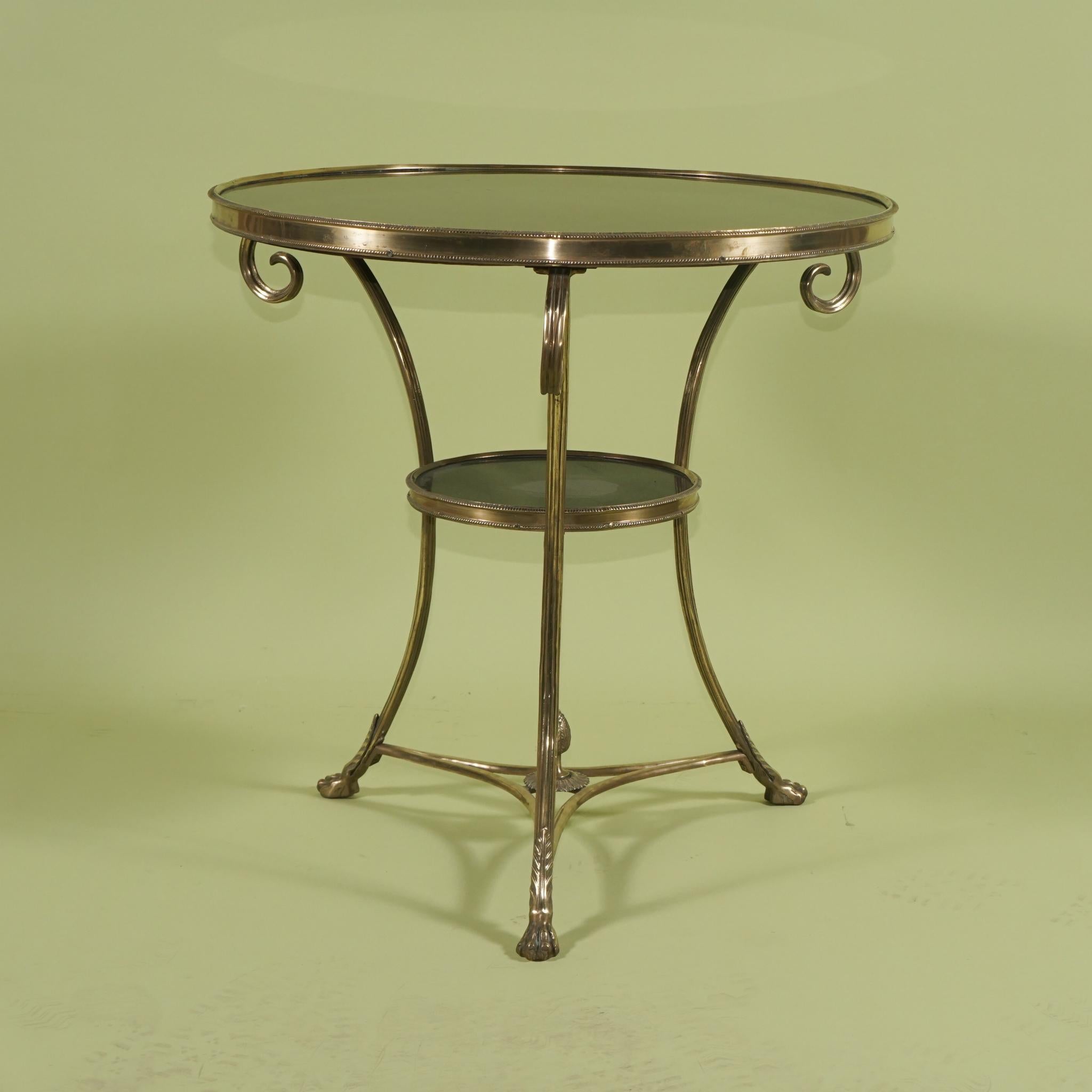 This table crafted by an expert metalsmith is made of bronze and then highly polished. Styled in the look of a late 18th or early 19th-century gueridon or occasional table the piece has a black marble top set within the bronze beaded border as well