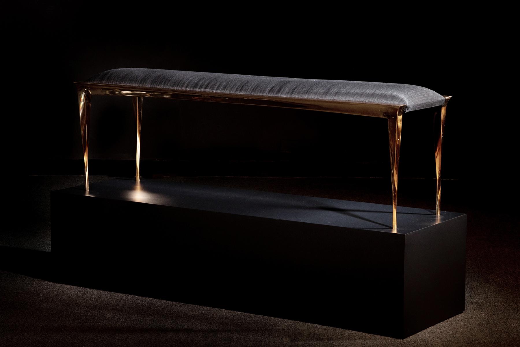 Long rectangular bench in polished bronze, the center upholstered with a narrow, low cushion in black fabric. 
Custom sizes and finishes available.