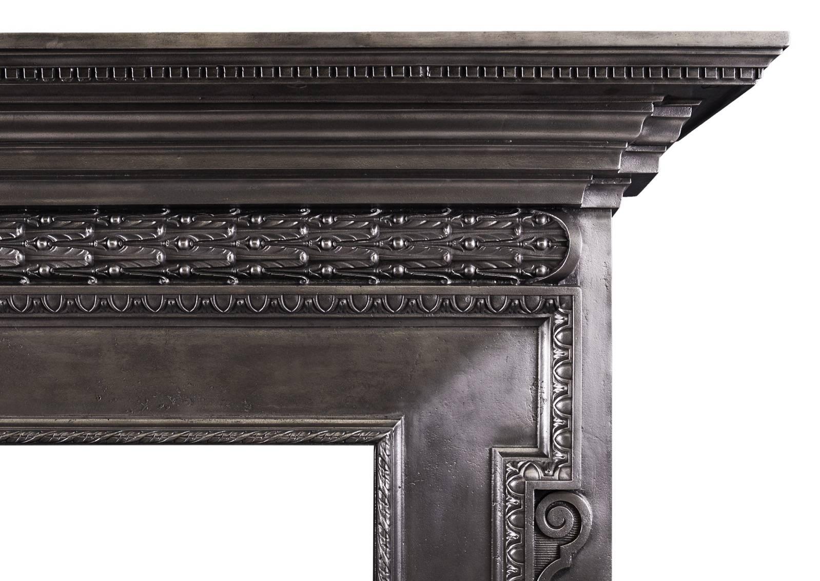 A polished cast iron fireplace in the mid-18th century style. The barrel frieze with flowing oak leaves and cross banded ribbon to centre. The jambs with scrollwork throughout with egg-and-tongue and rope moulding embellishments. Substantial moulded
