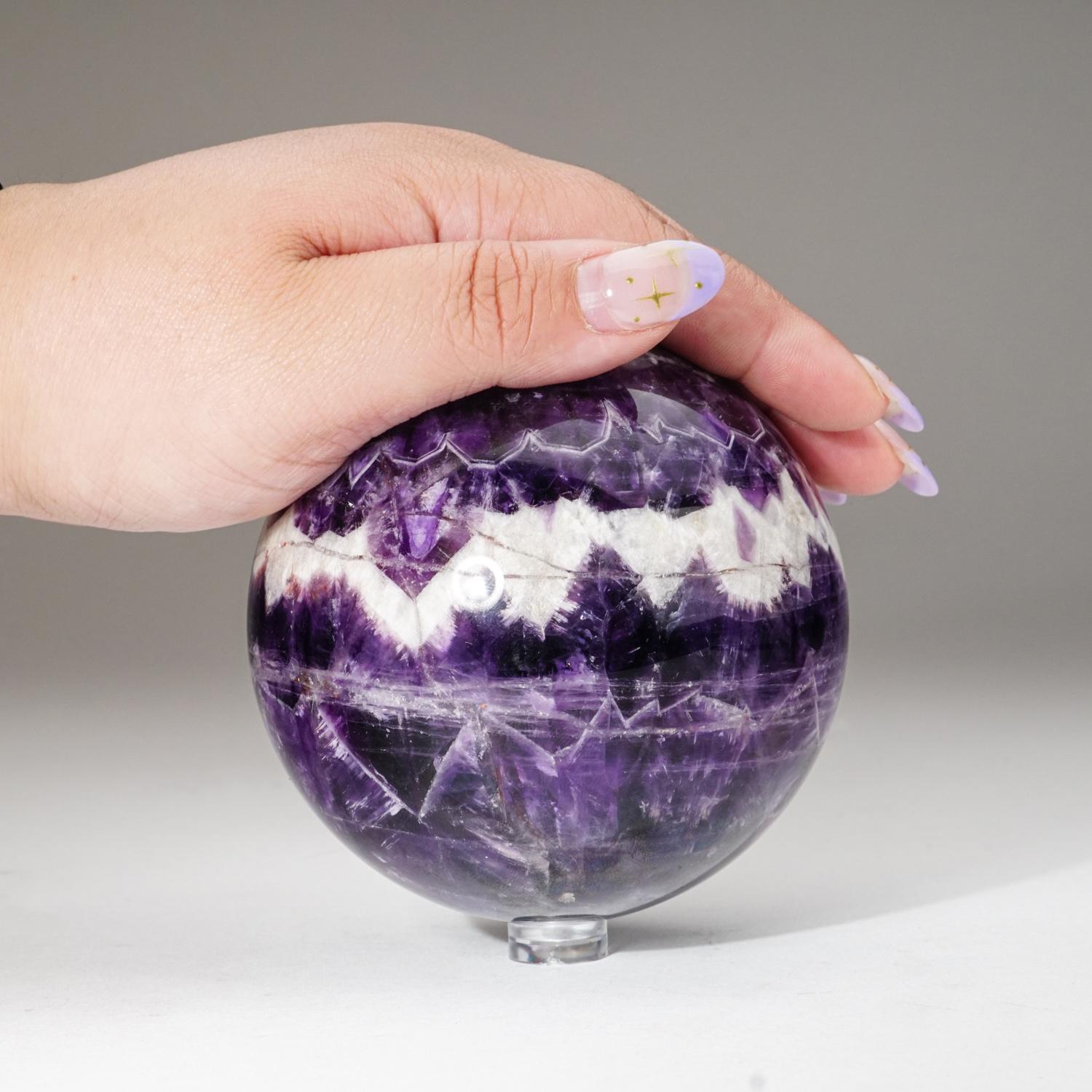 Sphère d'améthyste chevron de première qualité, polie, de couleur violet vif et de clarté translucide à transparente. L'améthyste chevron est une combinaison d'améthyste et de quartz blanc, mélangés ensemble dans un motif de bandes ou de rayures en