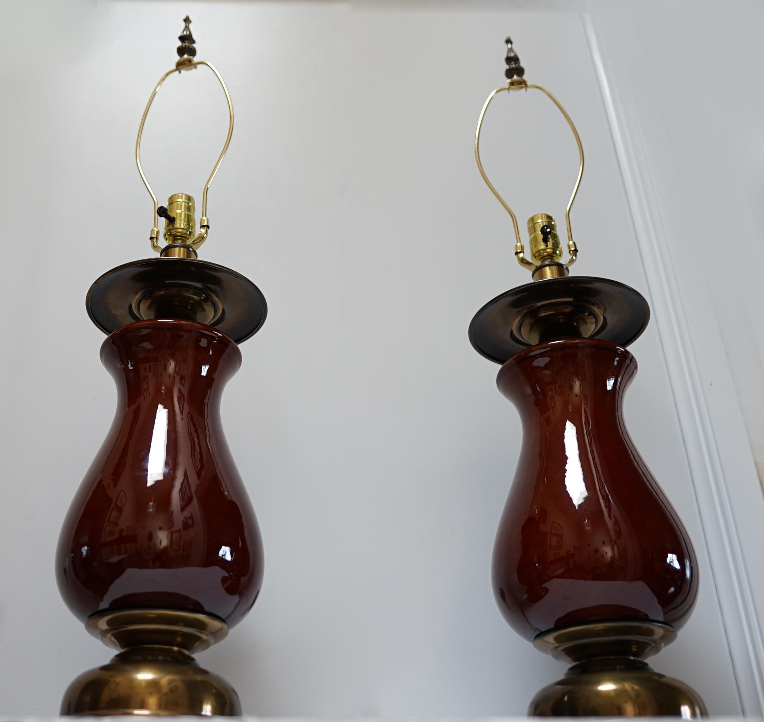 Cette paire de lampes balustres présente une gracieuse silhouette de style vase. La paire provient directement de la salle d'exposition. d'une vente aux enchères récente. Ils sont en excellent état, de la base à l'embout. La base présente un intérêt