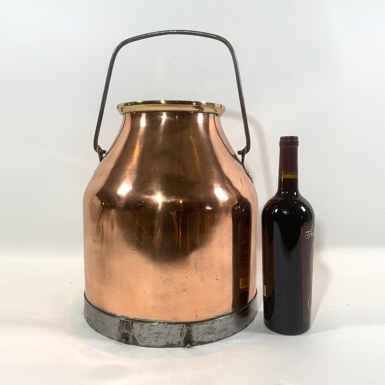 Polished copper cream pail with brass and nickel trim with steel carry handle.