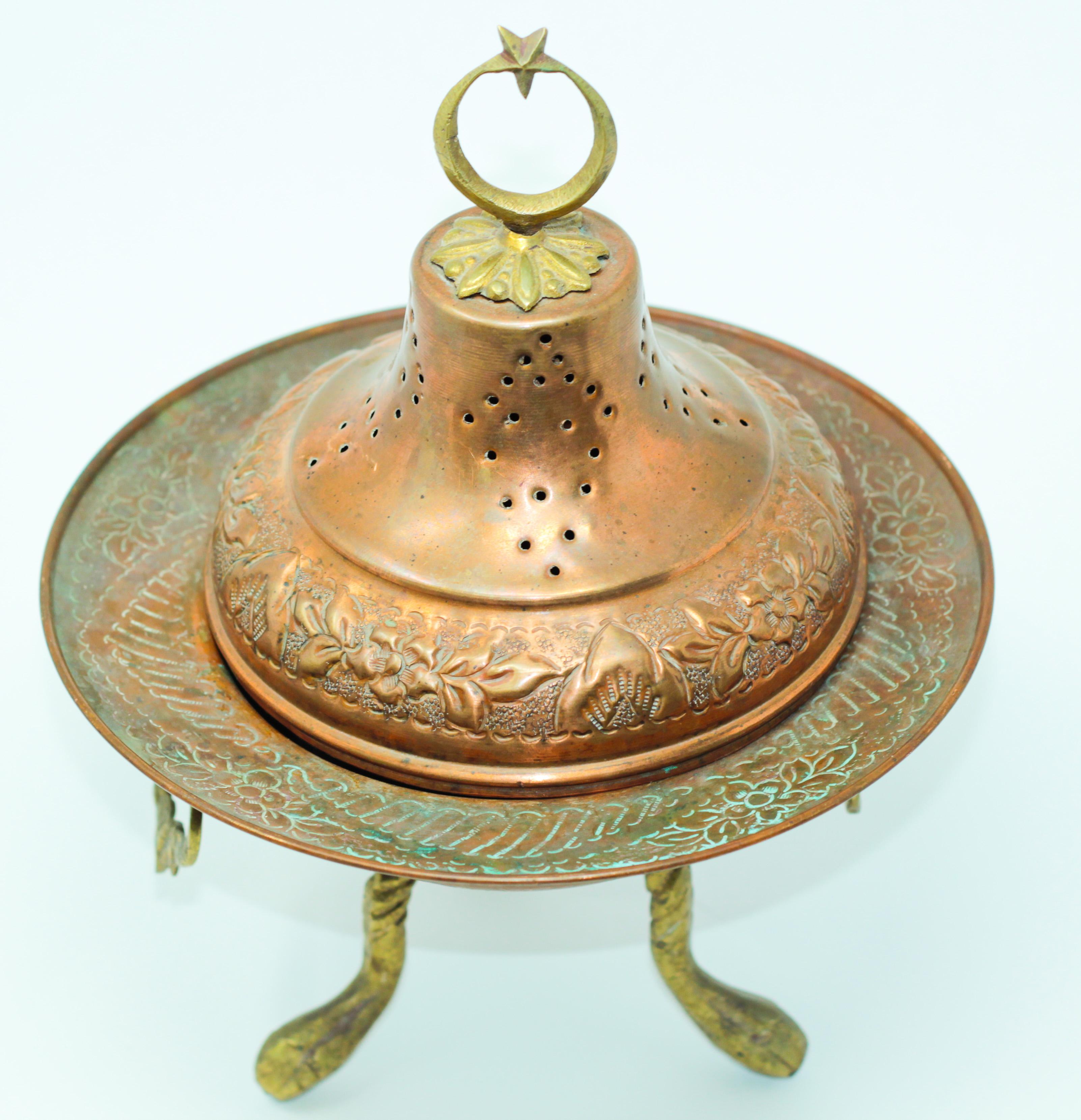 Footed antique Middle Eastern incense burner with pierced copper and brass ornamentation.
The lid is decorated with a crescent moon and star brass final.
Functional and beautifully adorned, complete with lid.
The footed copper bottom bowl with