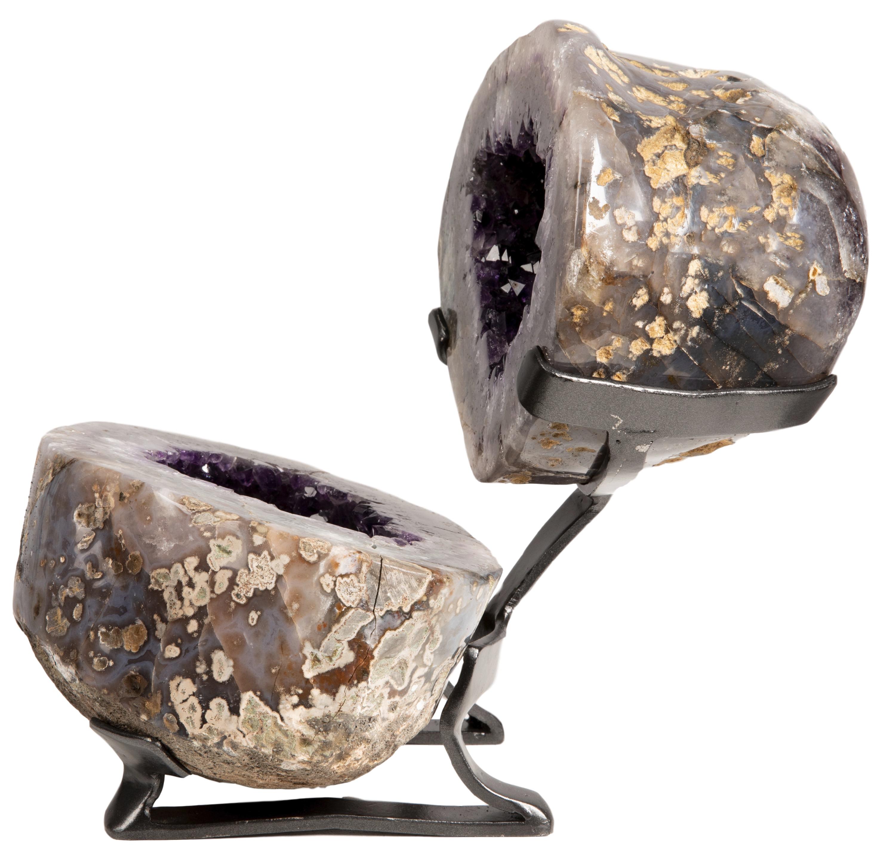 This is an extraordinarily complete geode, split in two atop a metal stand. This piece celebrates the visual phenomenon of the geode in its entirety, with some parts of the sculpture being rough basalt, and others showcasing combinations of the