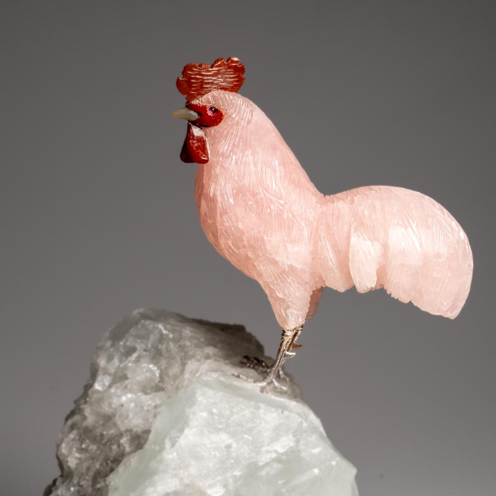 Questo gallo intagliato è un pezzo d'arte unico, scolpito in ametista di qualità museale con occhi di corniola. Il gallo è appollaiato in cima a una tormalina verde in una matrice di quarzo e montato su un supporto personalizzato per una comoda