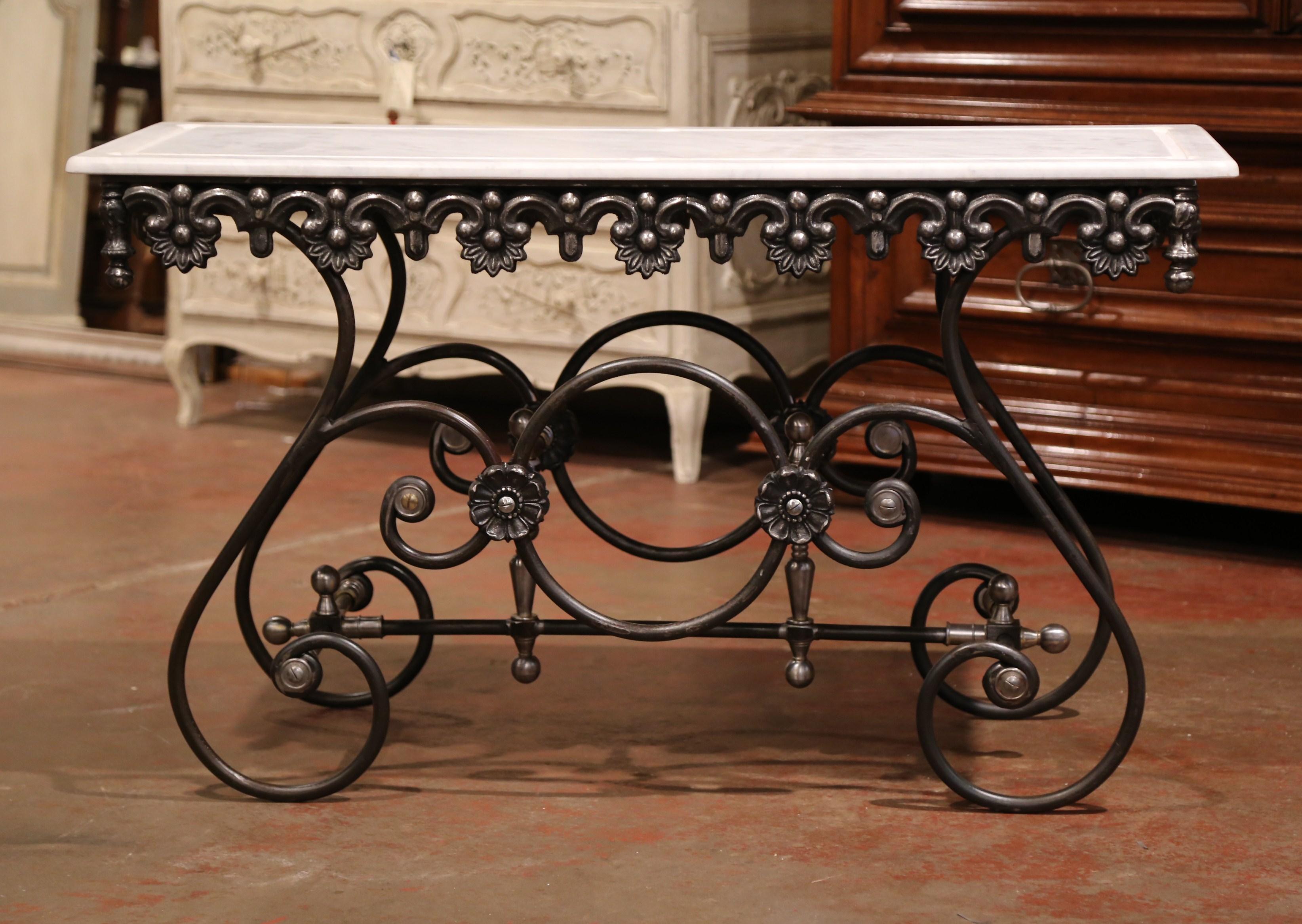 This long, narrow French butcher table (or pastry table) would add the ideal amount of surface space to any kitchen. Crafted of iron in France, this table features a scalloped apron with intricate metal work and beautiful scrolled legs with round