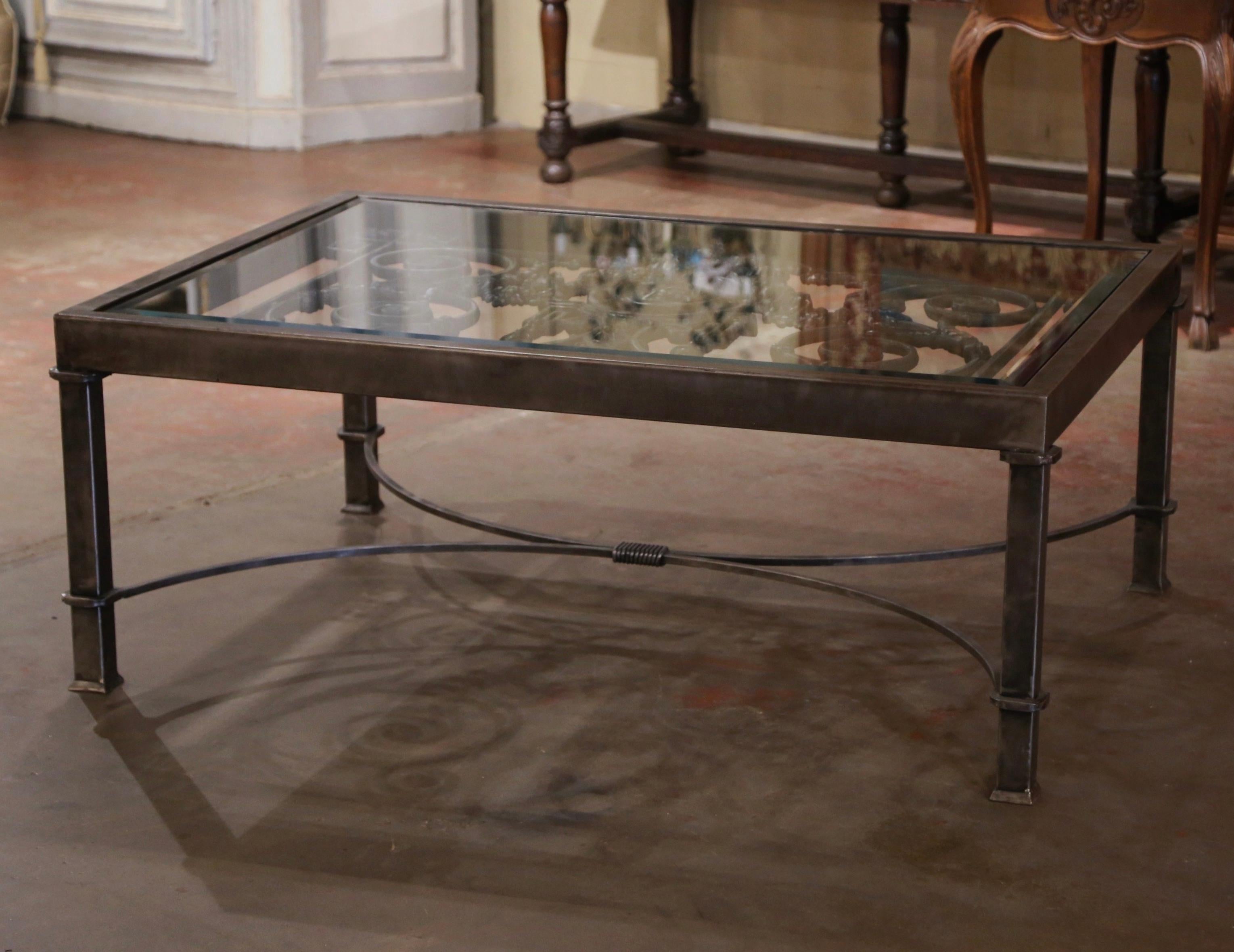 La base de cette grande table basse a été fabriquée à partir d'un portail antique orné provenant de France. Fabriqué en Provence vers 1850, ce portail présente un savoir-faire exceptionnel qui met en valeur son charme historique. La table repose sur