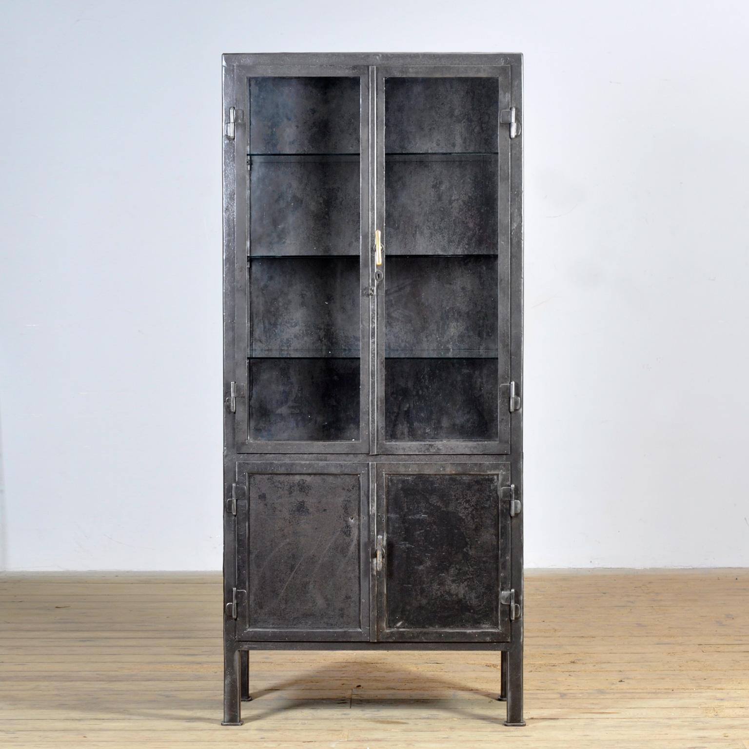 Cabinet médical original des années 1920, fabriqué en Allemagne. Cette armoire est fabriquée en fer et en verre, ce qui lui confère un aspect industriel robuste. L'armoire a été soigneusement décapée jusqu'au métal et finie avec une huile