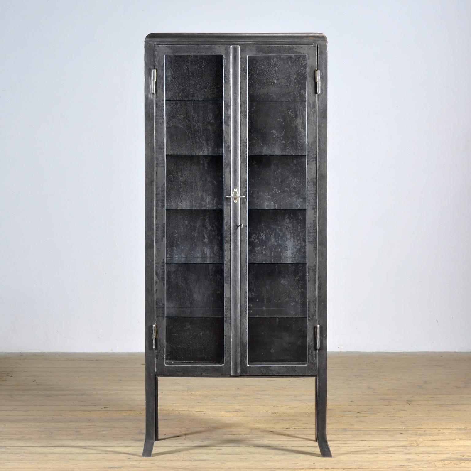 Armario médico de los años 30, fabricado en Hungría. Este armario está hecho de hierro y cristal, creando un robusto aspecto industrial. El armario se desnuda hasta el metal y se acaba con un aceite resistente al óxido, conservando su carácter