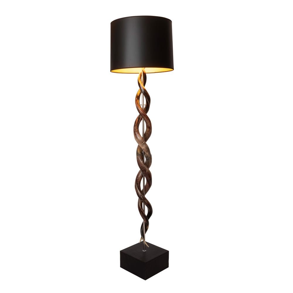 Handcrafted in South Africa, this naturally elegant floor lamp features four intertwined African kudu horns that appear to be suspended above a wooden base, which is wrapped in top-stitched embossed leather. All hide and horn has been sustainably
