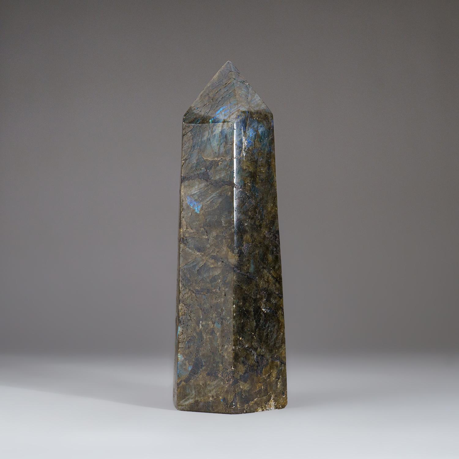 High quality 9.75 inch tall handmade polished Labradorite Obelisk from Madagascar. It has beautiful iridescent play of colors of blue, yellow and red which is caused by internal fractures in the mineral that reflect light back and forth, dispersing