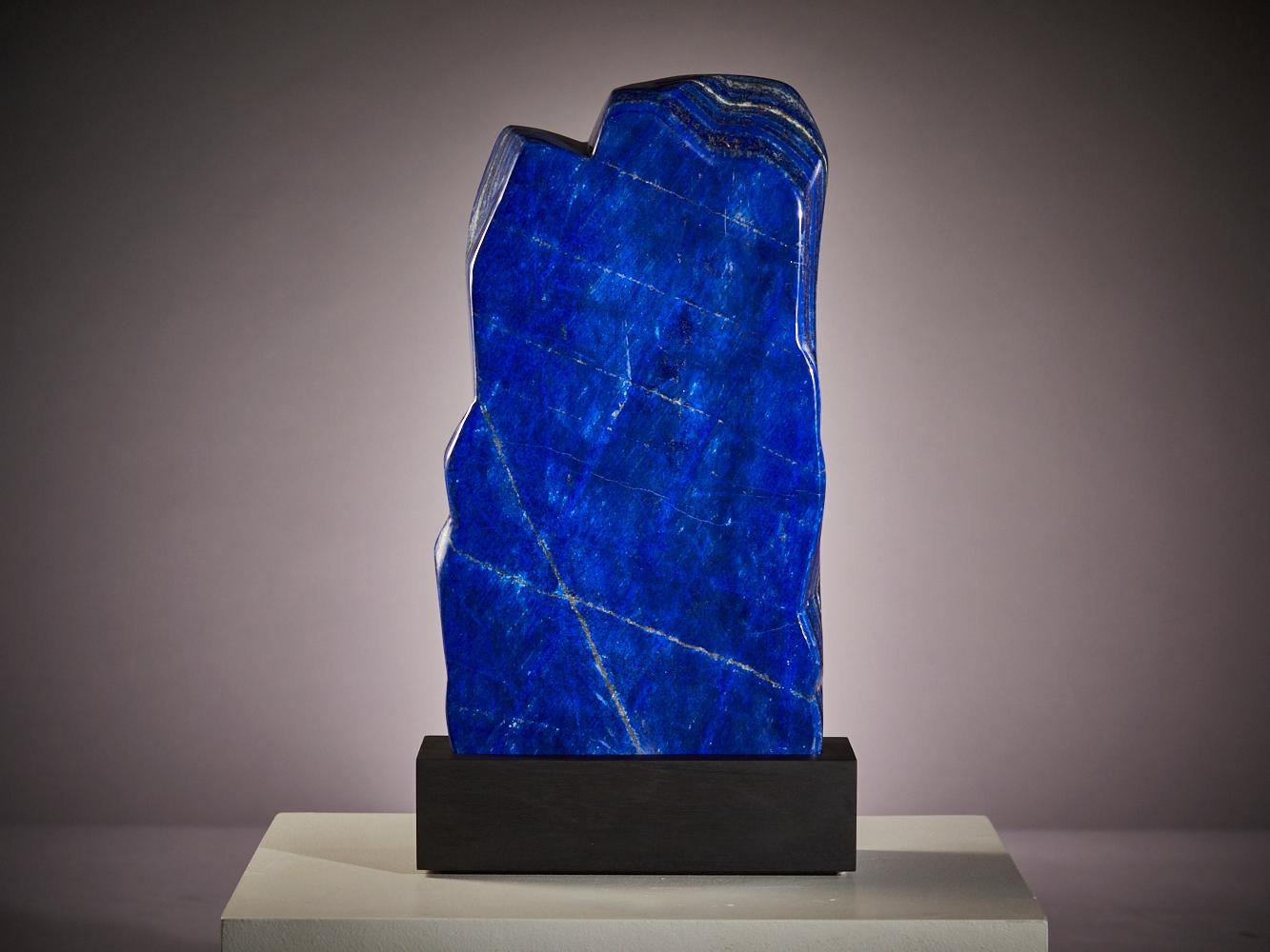 Questa straordinaria lastra di lapislazzuli proveniente dall'Afghanistan mostra un colore intenso e regale.
di colore blu, drammaticamente intersecata da venature naturali di calcite bianca e di
scintillante pirite dorata. 

Sapientemente lucidato