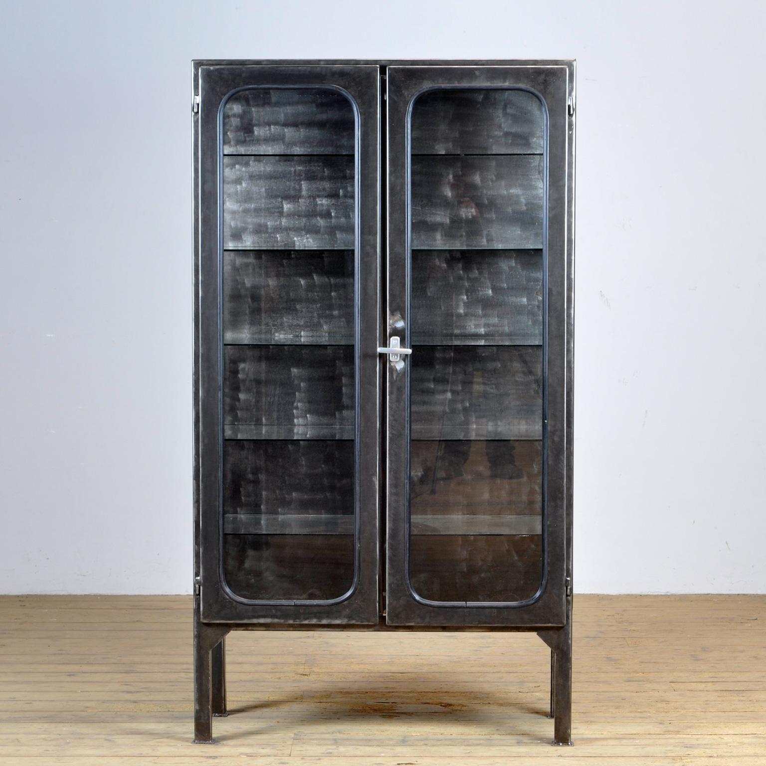 Made of steel and glass that is clamped in the steel by a rubber strip. The cabinet is from the 1970s and was produced in Hungary. The cabinet has been stripped to the metal and finished with a transparent lacquer. The cabinet comes with 5 glass