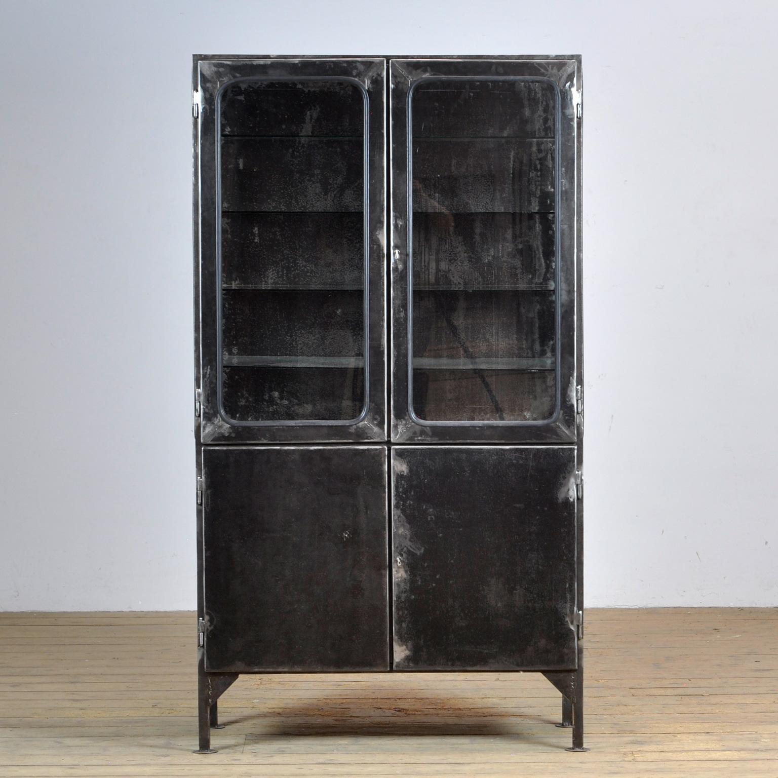 Made of steel and glass that is clamped in the steel by a rubber strip. The cabinet is from the 1970s and was produced in Hungary. The cabinet has been stripped to the metal and finished with a transparent lacquer. The cabinet comes with 4 glass