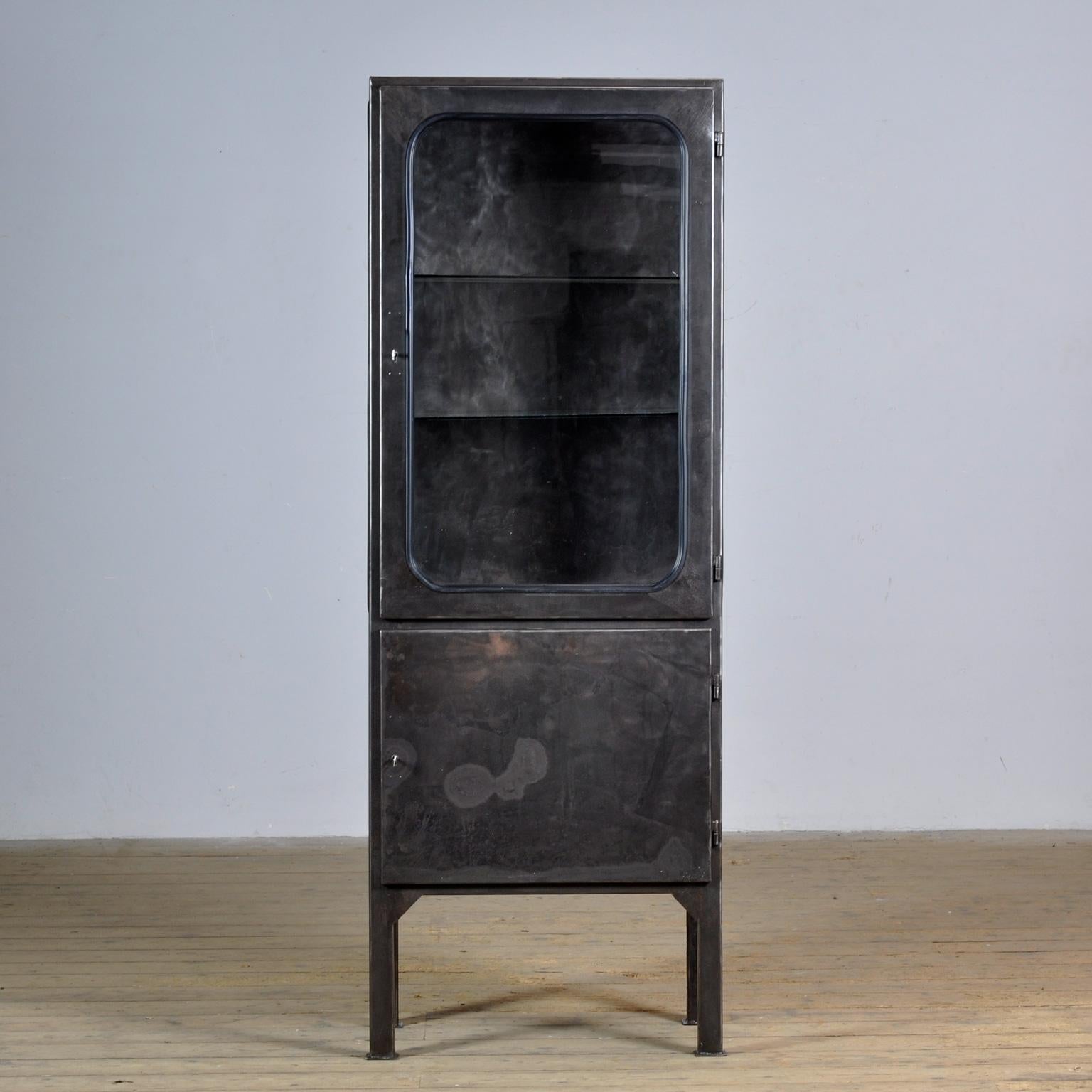 Medical cabinet made of iron and glass that is clamped into the iron by a rubber strip. The cabinet comes from the 70s and is produced in Hungary. The cabinet is stripped down to the metal and finished with rust-resistant oil. The cabinet comes with