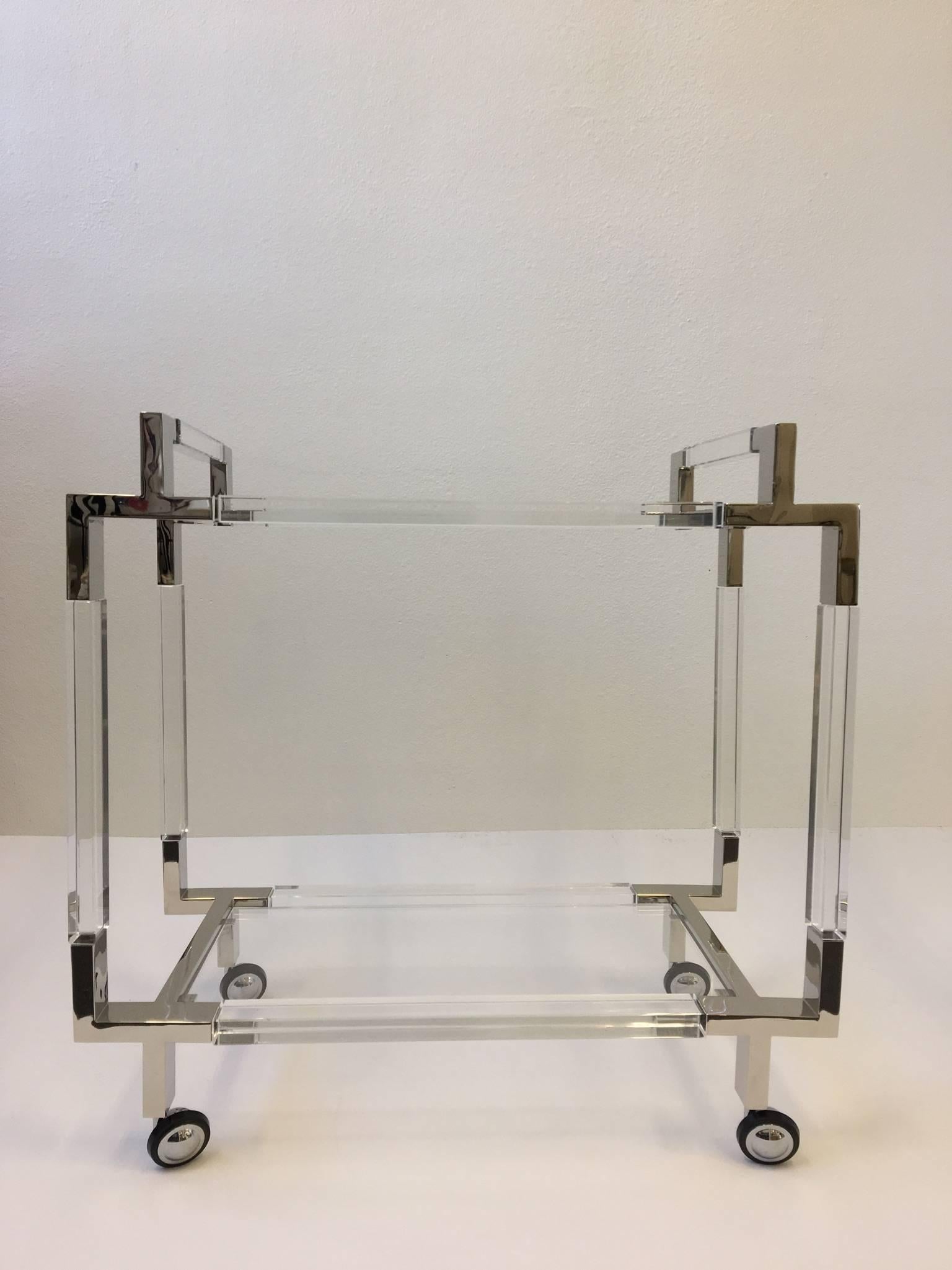 A glamorous polish nickel and clear acrylic bar cart designed by American renowned designer Charles Hollis Jones in 1963. The cart is from the 