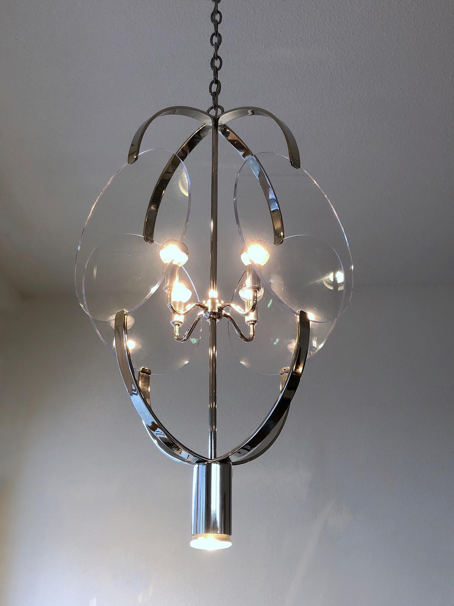 ‘O Hanging Fixture’ chandelier design in the 1970s by Renowned American designer Charles Hollis Jones.
Constructed of polished nickel plated steel and clear Lucite.
The Pendant takes four candelabra lightbulb and one down spotlight.
