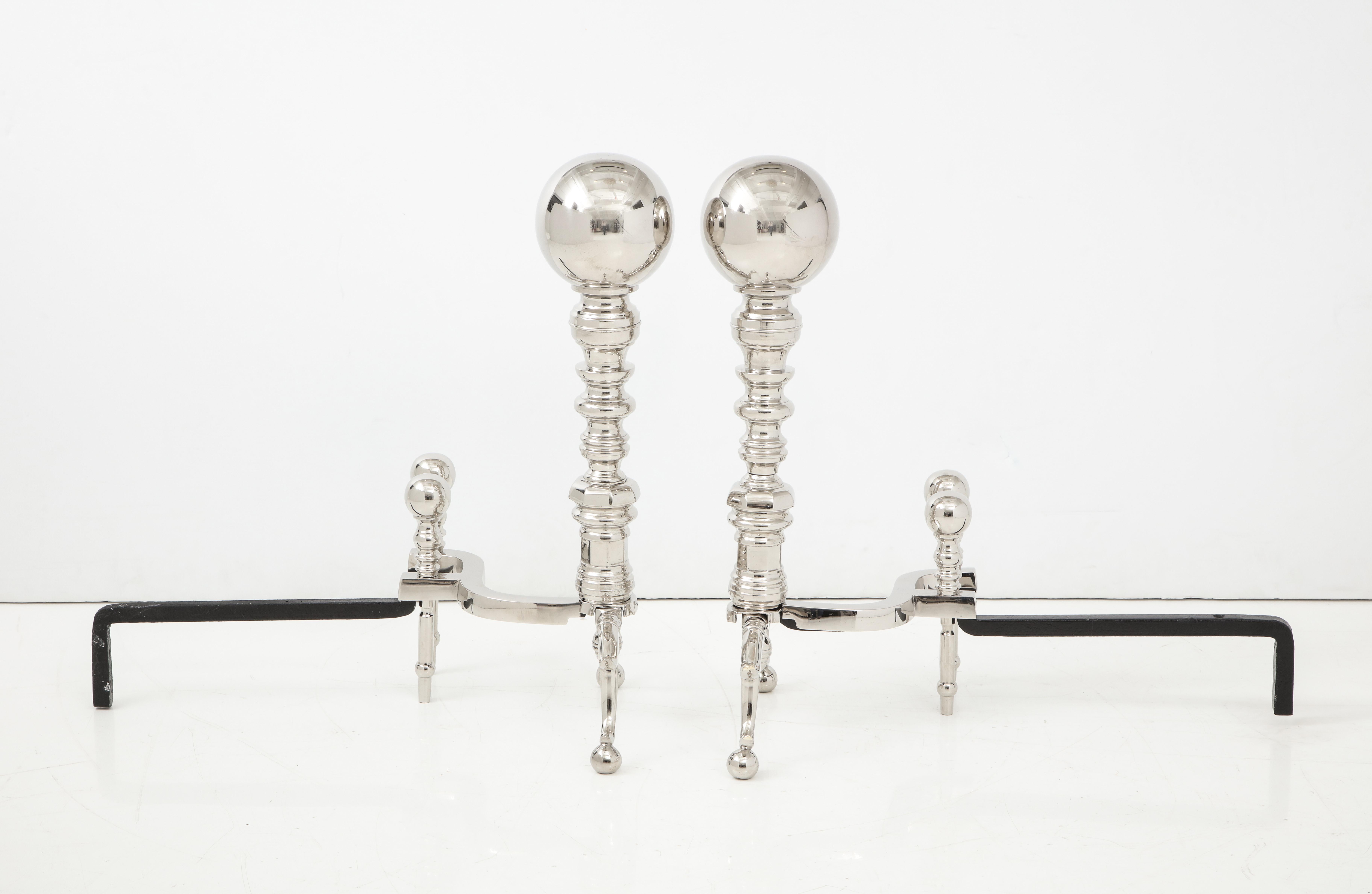 Pair of stately large scale polished nickel andirons with engine turned centers and cannonball tops. Blackened iron backs have dual finials.