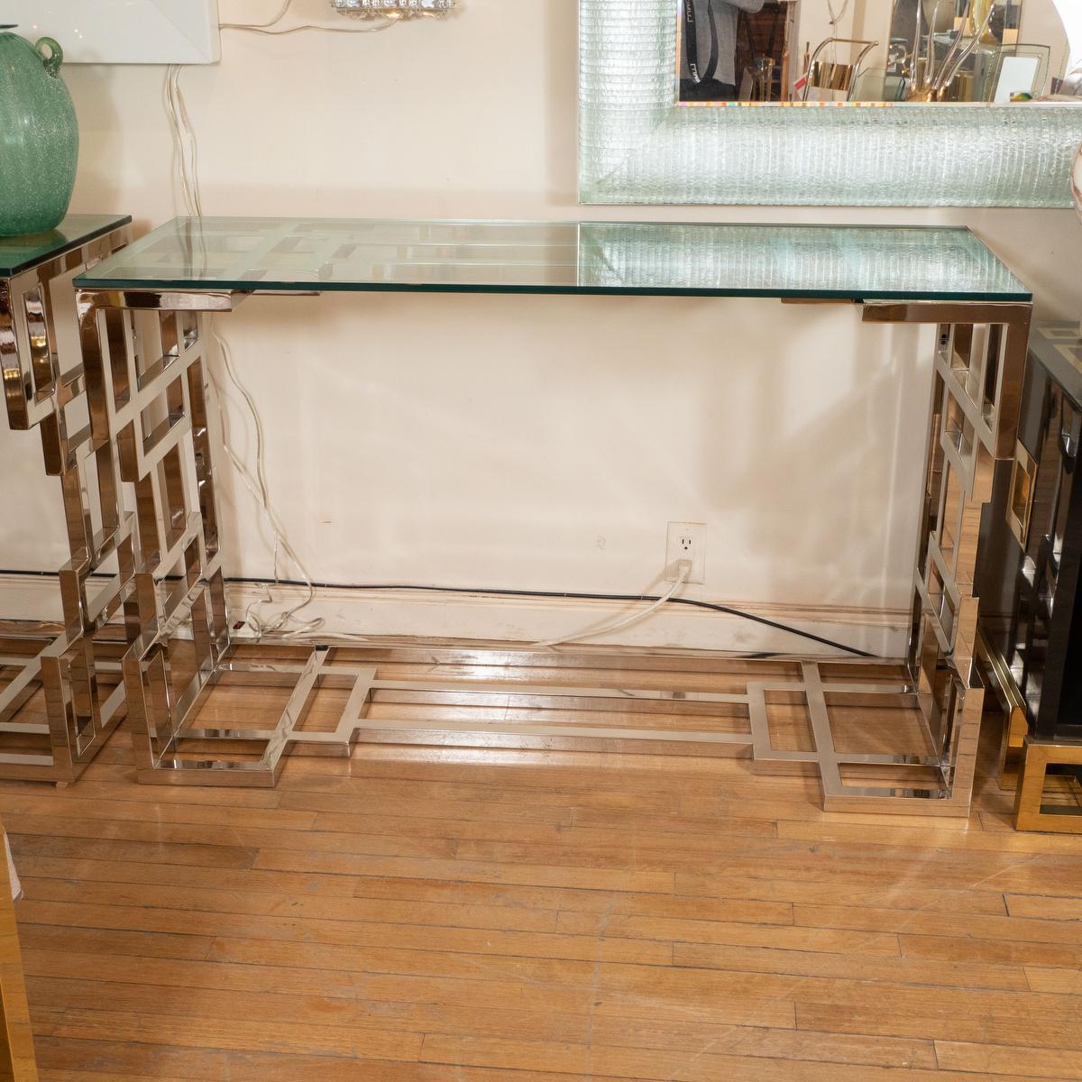 Polished nickel geometric design console table with glass top.