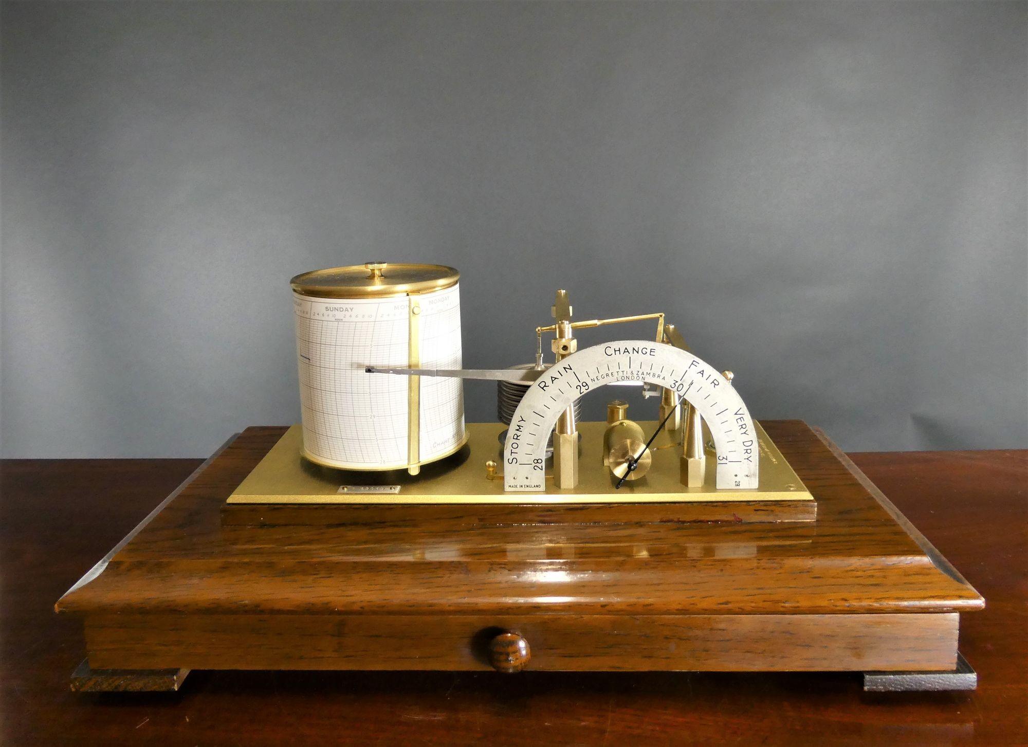 Edwardian polished oak cased barograph with bevelled glass panels.
Brass base plate stamped ‘Regent, Jewelled movement supporting the ten vacuum chambers linking the ink pen pointer to the revolving clockwork drum and to the silvered barometer dial.