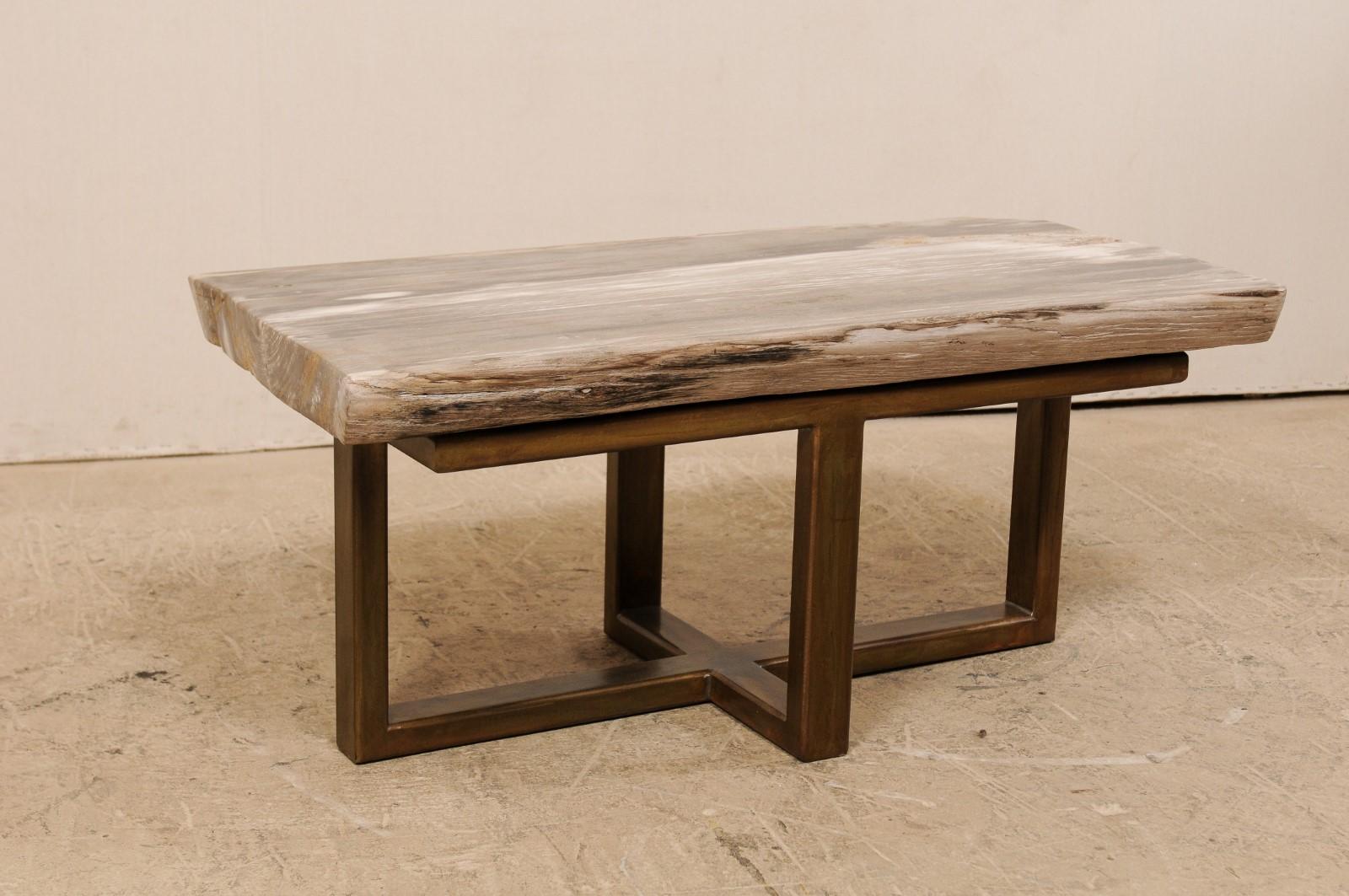 A petrified wood top modernly designed coffee table (or bench). This custom coffee table has been fashioned from a gorgeous single thick slab of smoothly polished petrified wood, with an overall rectangular-shape, approximately 3.5 feet in length.