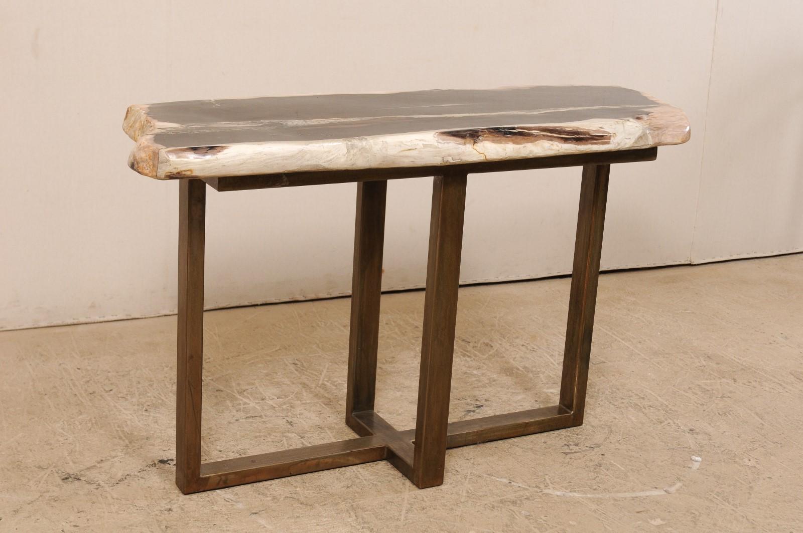 A petrified wood top modernly designed console table. This custom console table has been fashioned from a single thick slab of smoothly polished petrified wood, almost 4.5 feet in length. This fabulous petrified wood top is mostly black with shades