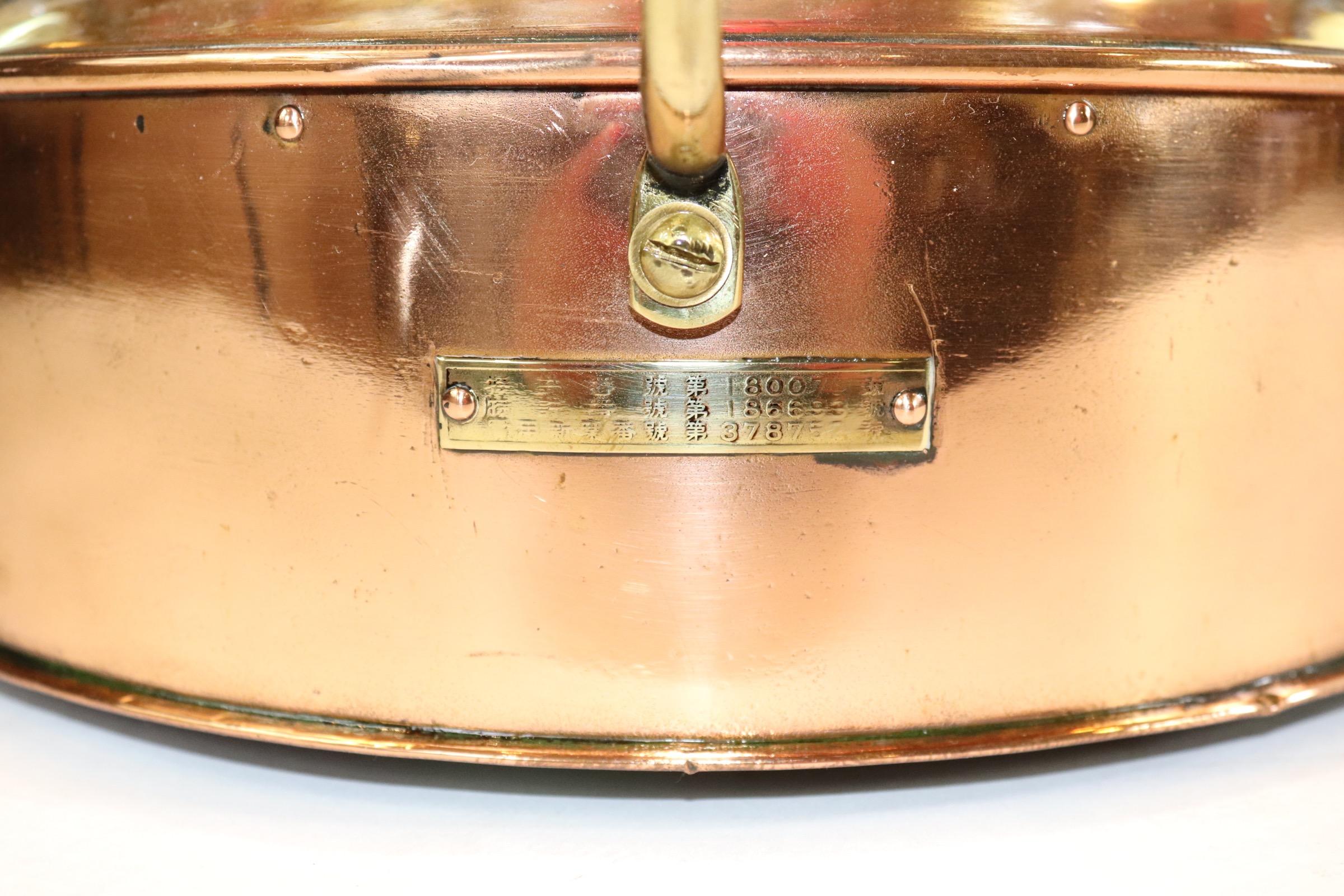 Polished and lacquered ships port lantern with Fresnel glass lens, removable red filter, protective brass bar, hinged rear door and a new wire and socket for home display. With brass makers badge from Japanese maker Nippon Sento and dated 1955.