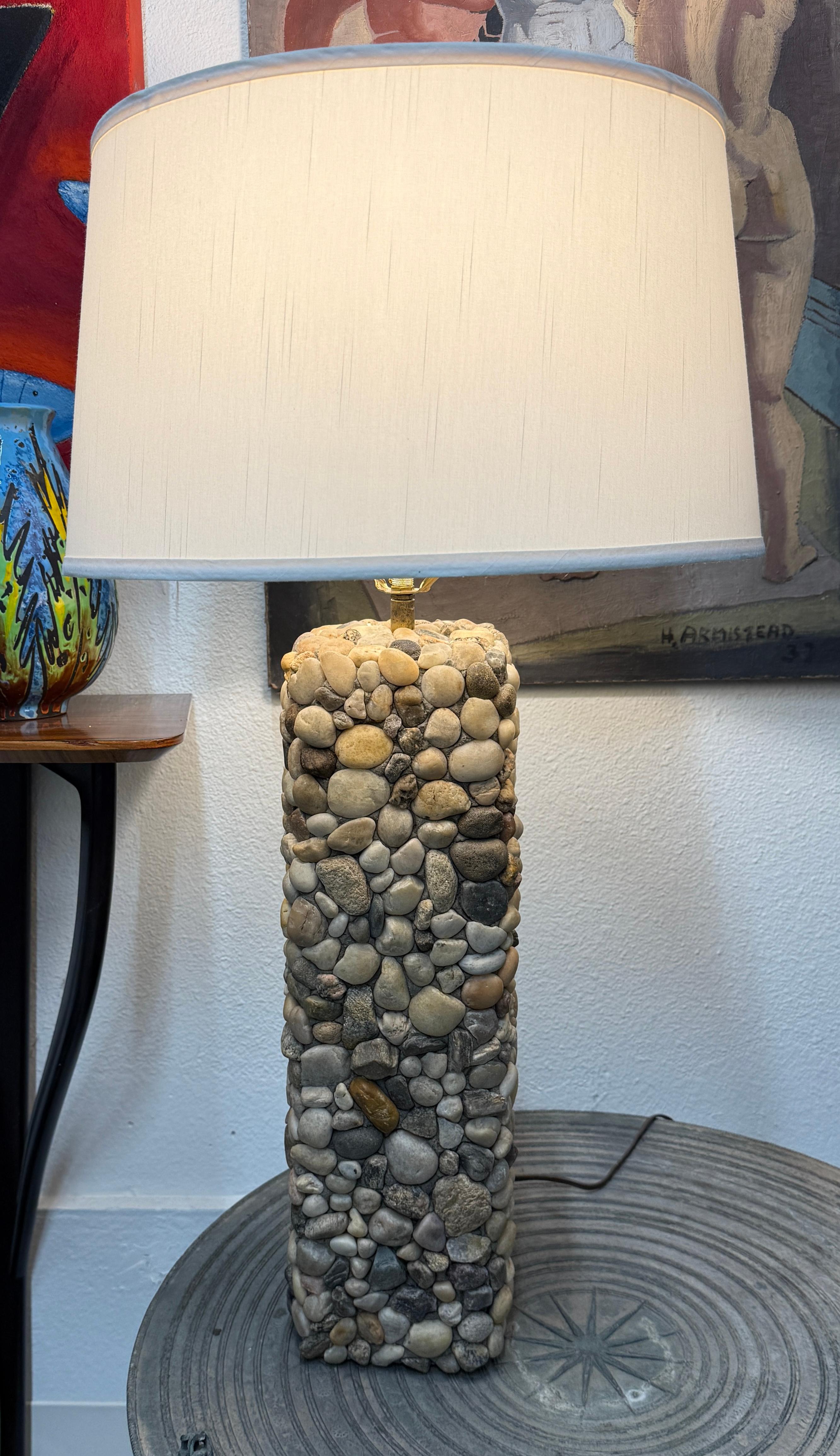 Una bonita lámpara de piedra de río hecha a mano con accesorios de latón. Esta lámpara es muy bonita y está fabricada de forma única con diferentes piedras. La lámpara funciona correctamente. Base de fieltro. Consulta el par a juego más pequeño que