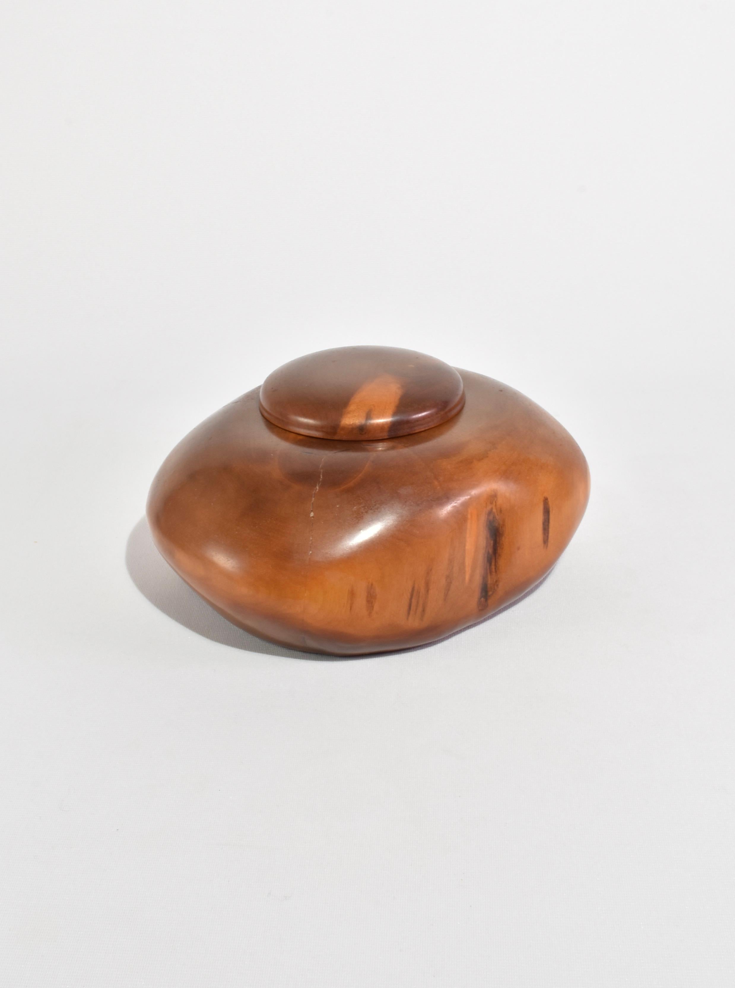 Hand-crafted wooden box in an organic round shape. 