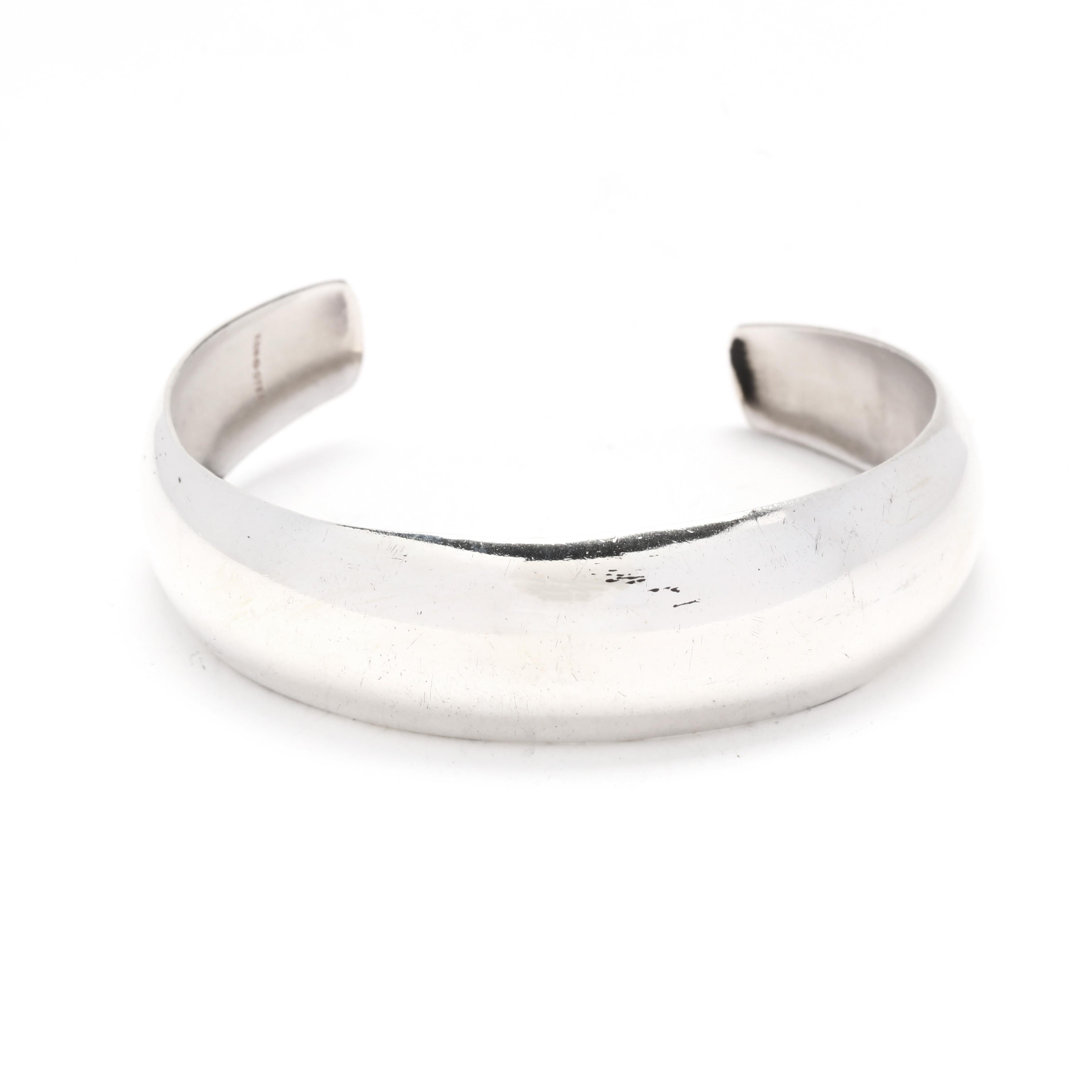 A vintage sterling silver polished rounded cuff bracelet.  This wide cuff bracelet has a rounded form with a tapering shape.  It is stamped KBN Ster. 

Length: 6.5 inches with a 1-inch opening

Width: .5 inches

Weight: 8.4 dwt / 13.1 grams

Metal: