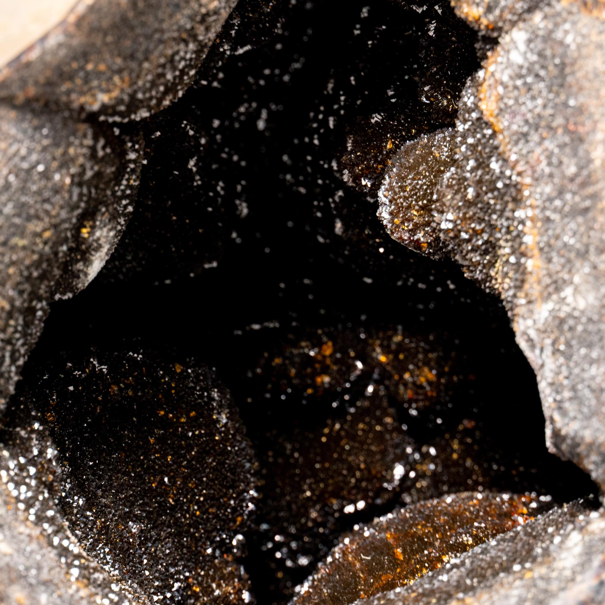 Questo uovo di geode druzico settariano di alta qualità, proveniente dal Madagascar, presenta un'area esposta rivestita di cristalli di quarzo druzico abbaglianti e un lato posteriore lucidato, che offre una superficie altamente riflettente. Il