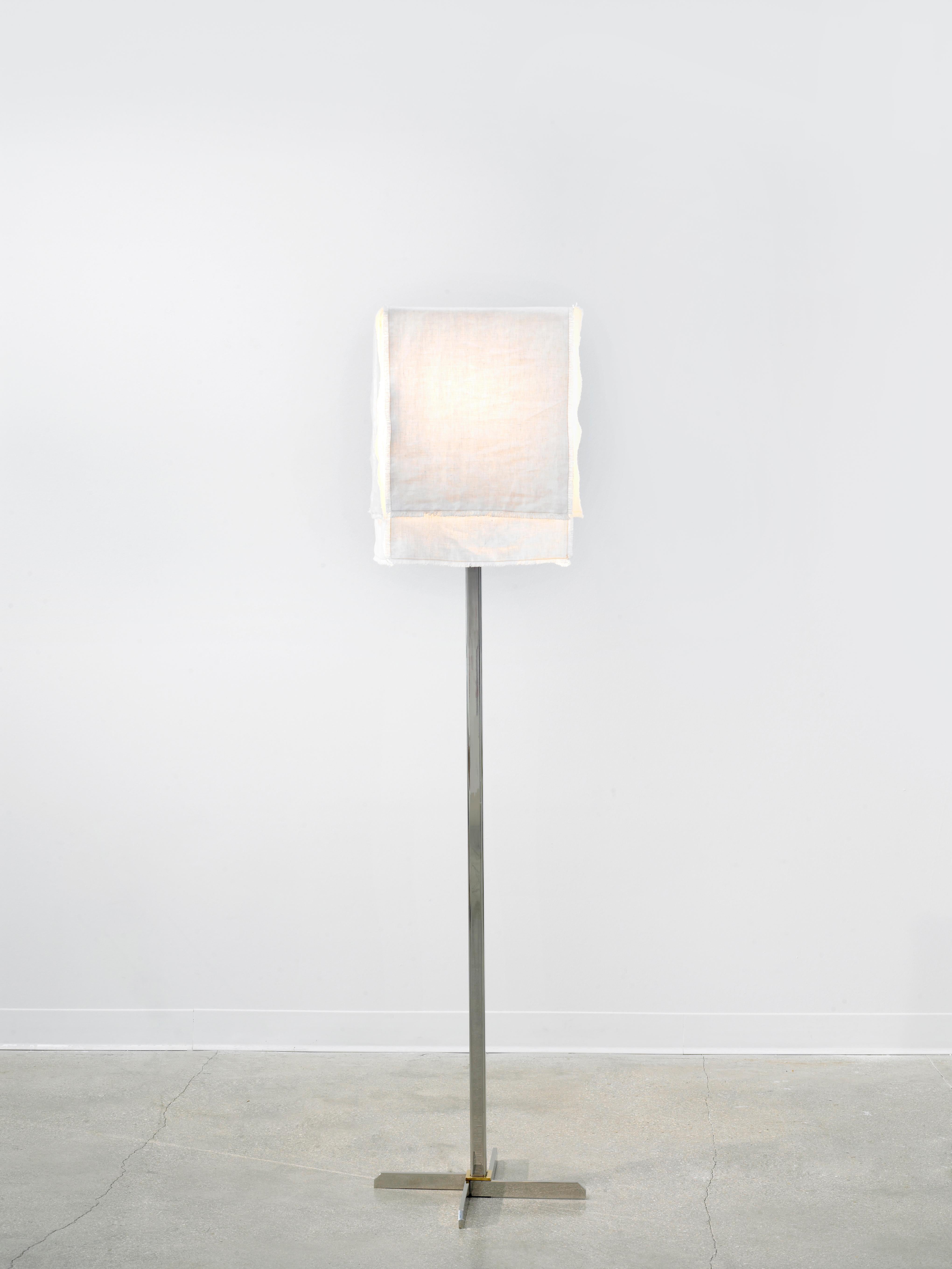 The Axis floor lamp is made of polished stainless steel, bronze and a custom four panel linen shade. The panels can be adjusted to create layered or even light filtration. The relaxed flow and texture of the shade compliments the structured metal