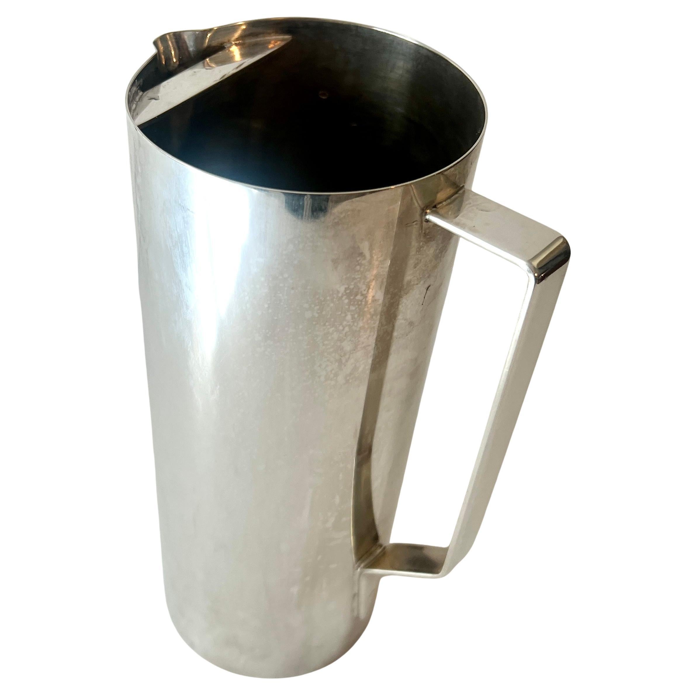 A simple, architecturally appealing, Stainless Steel Martini or Cocktail pitcher designed by Valerio Albarello.  We added a glass and stainless stir stick.  A handsome piece for any bartender!!

A complement to any bar due to it's simplicity - Chic