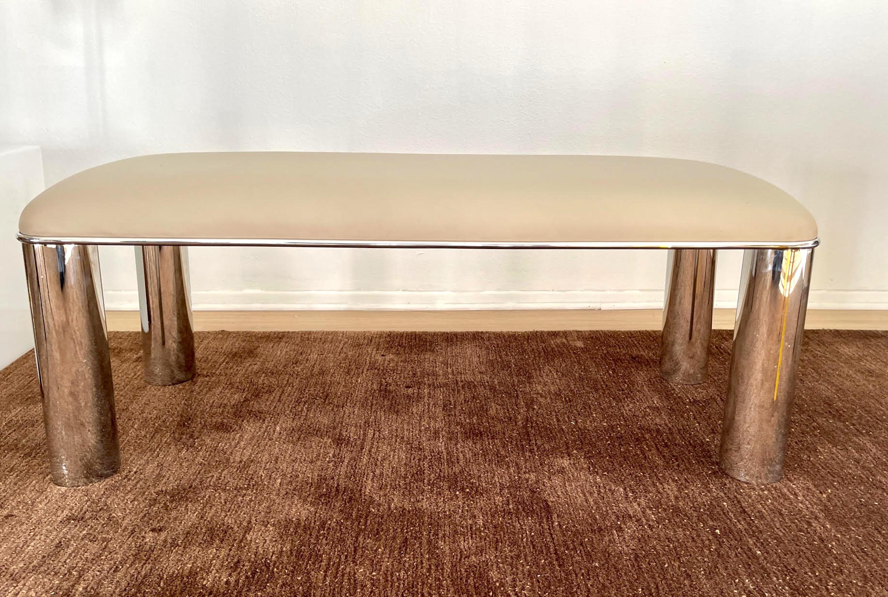 Upholstered Beige Leather Bench with polished steel legs and edge. 
Supported underneath with a steel cross frame. Excellent quality, heavy, sturdy, and ready for use.