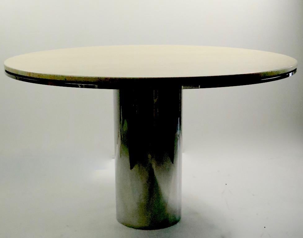 Chic and sophisticated round dining table having a cylindrical polished steel base with a polished travertine marble top. The table is in very fine, original condition, clean and ready to use. Anello by Brueton, voguish style dining table.